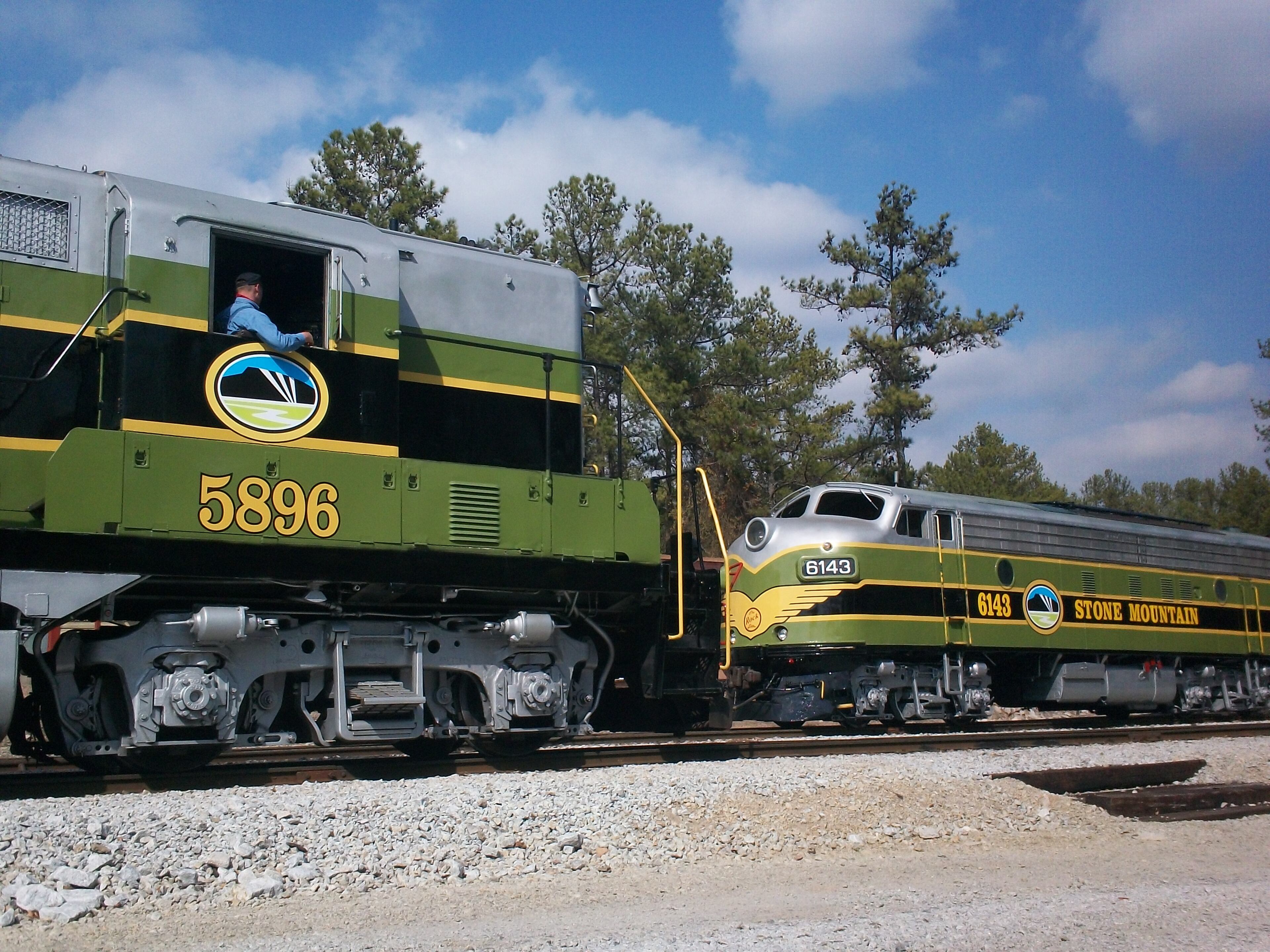 The Stone Mountain Railroad at Stone Mountain Park features open-air cars pulled by full-size 1940s locomotives. The line itself is an industrial spur dating to 1869. The Stone Mountain Granite Company used it to serve quarries at the base of the mountain. The current route opened in 1962.