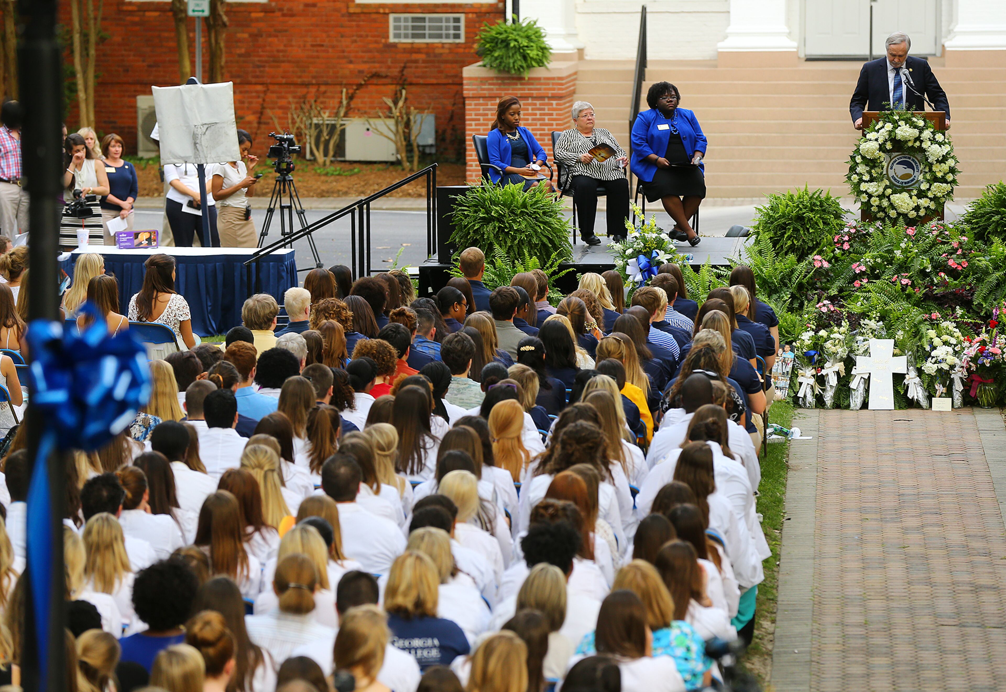Nursing students in while lab coats listen to Georgia Southern University president Brooks A. Keel (top right) during the Memorial Service on Sweetheart Circle for five nursing students who died in a vehicle pileup on April 22, 2015, in Statesboro. Curtis Compton / ccompton@ajc.com