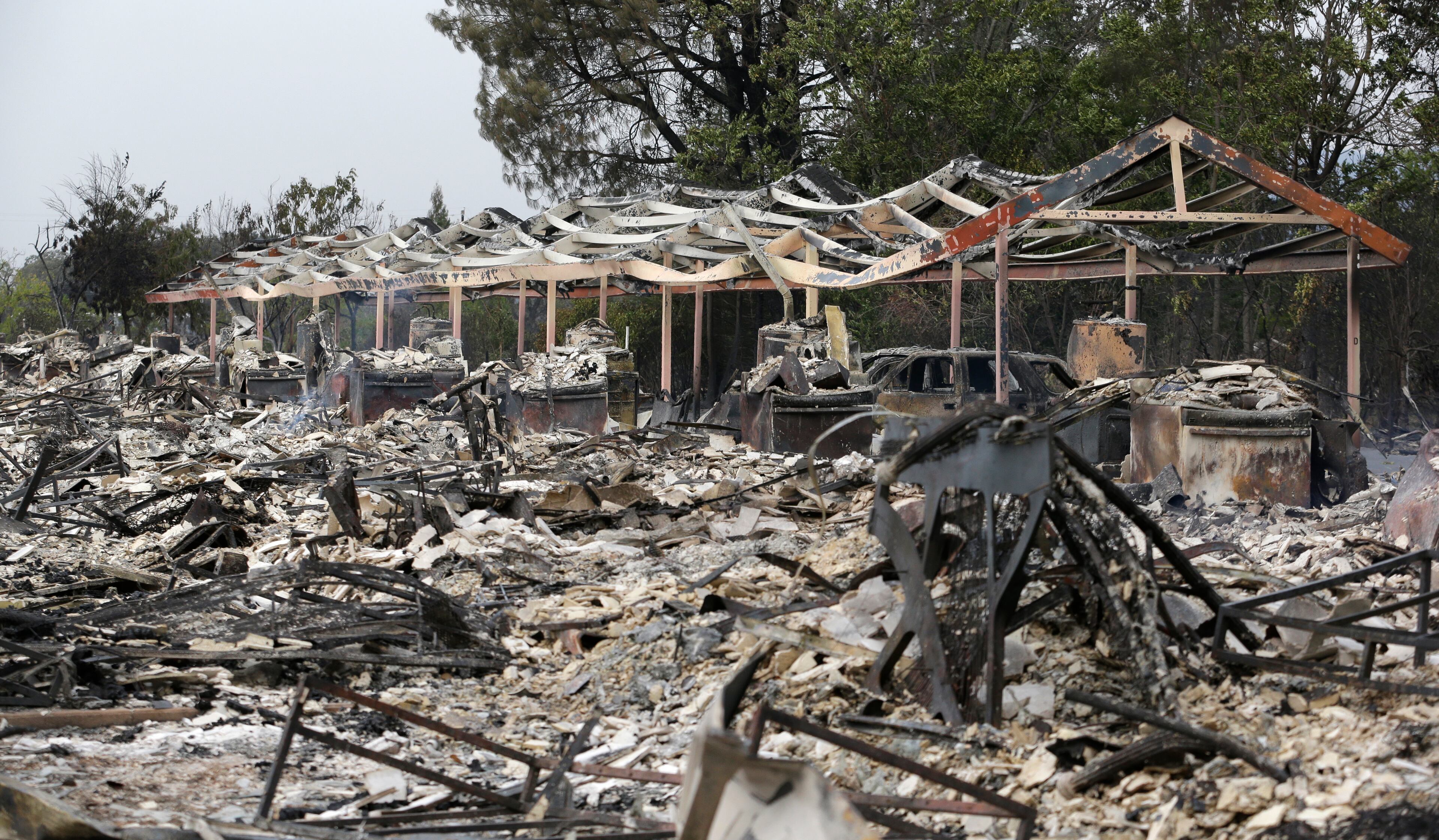 The charred remains of an apartment complex remain that burned from a wildfire tow days earlier stand Monday, Sept. 14, 2015, in Middletown, Calif. Two of California's fastest-burning wildfires in decades overtook several Northern California towns, killing at least one person and destroying hundreds of homes and businesses and sending thousands of residents fleeing highways lined with buildings, guardrails and cars still in flames. (AP Photo/Elaine Thompson)