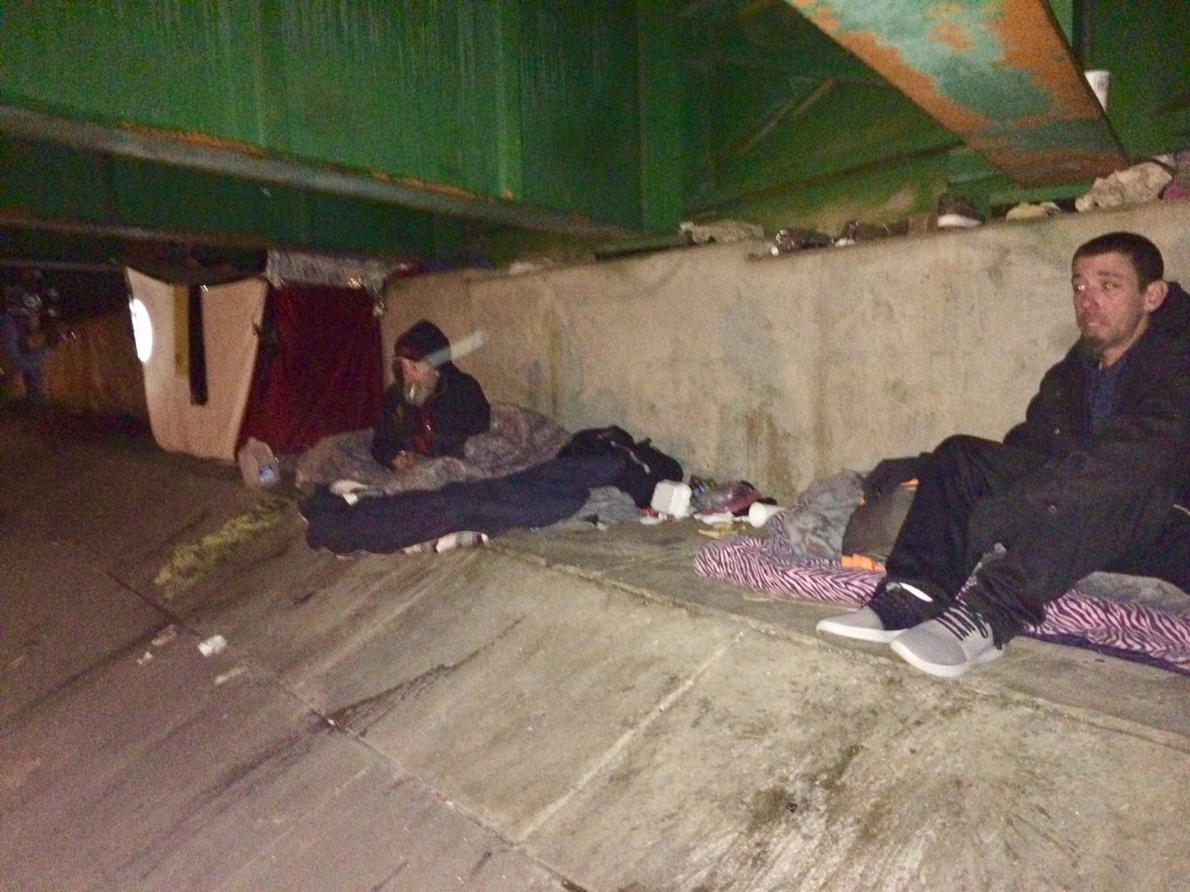 Thomas Wardham (right) sets up for the night under I-20 in Atlanta after being interviewed in the annual homeless count.