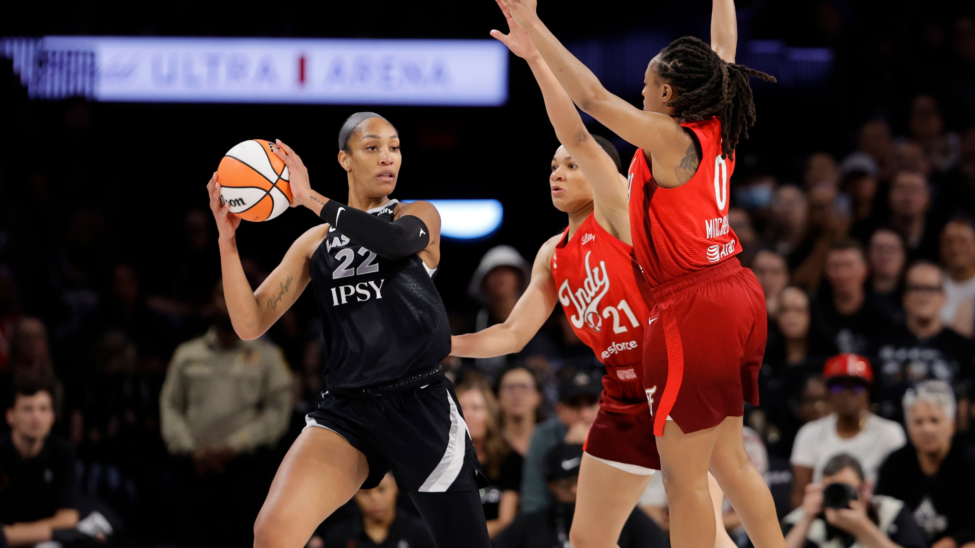 Las Vegas Aces center A'ja Wilson (22) is pressured by Indiana Fever forward Makayla Timpson (21) and guard Kelsey Mitchell (0) during the first half in Game 3 of an WNBA basketball first-round playoff series Thursday, Oct.1, 2026, in Las Vegas. (AP Photo/Steve Marcus)