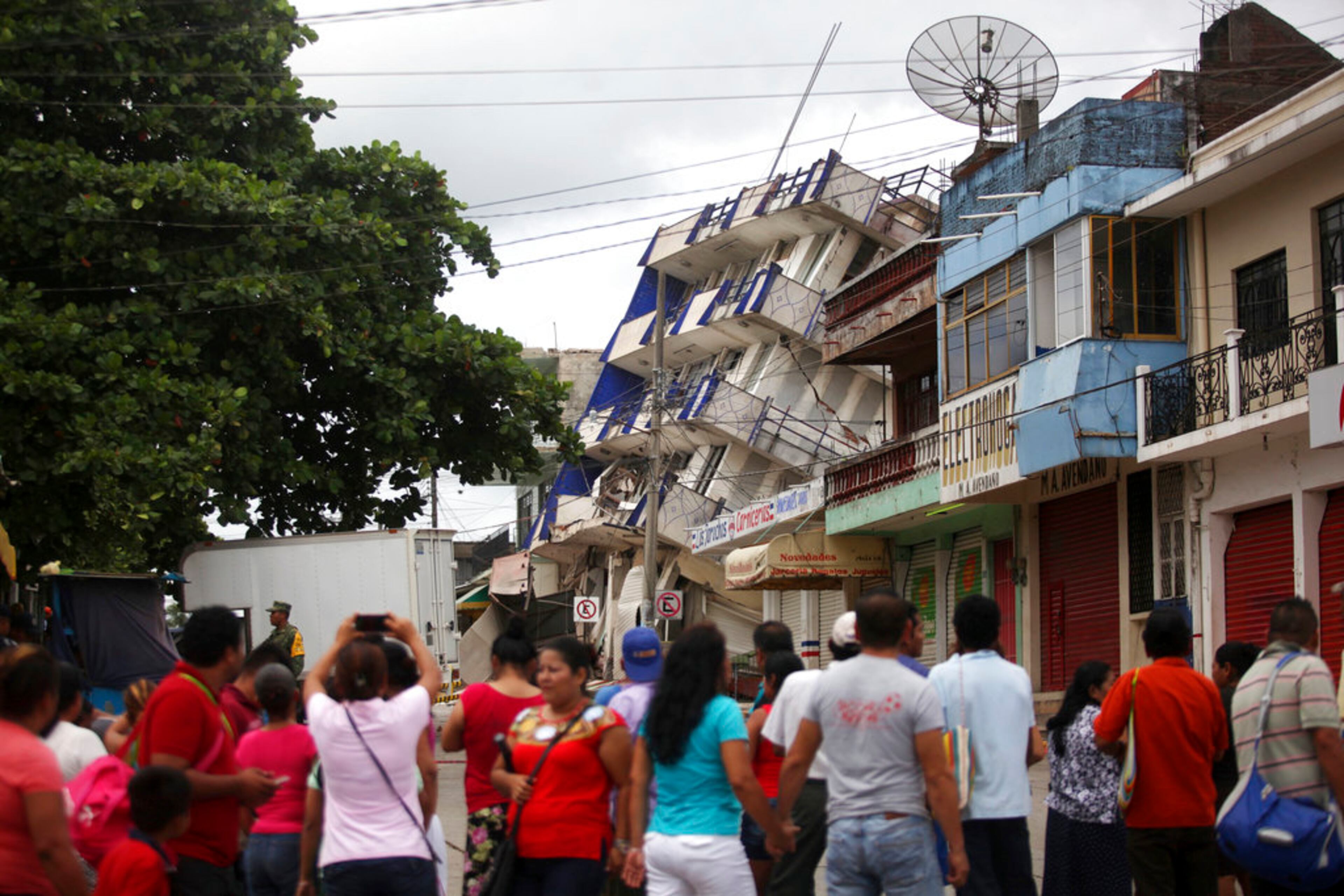 Residents look at a partially collapsed hotel in Matias Romero, Oaxaca state, Mexico, Friday, Sept. 8, 2017. One of the most powerful earthquakes ever recorded in Mexico struck off the country's southern coast, toppling hundreds of buildings, triggering tsunami evacuations and sending panicked people fleeing into the streets in the middle of the night. At least 35 people were reported killed. (AP Photo/Felix Marquez)