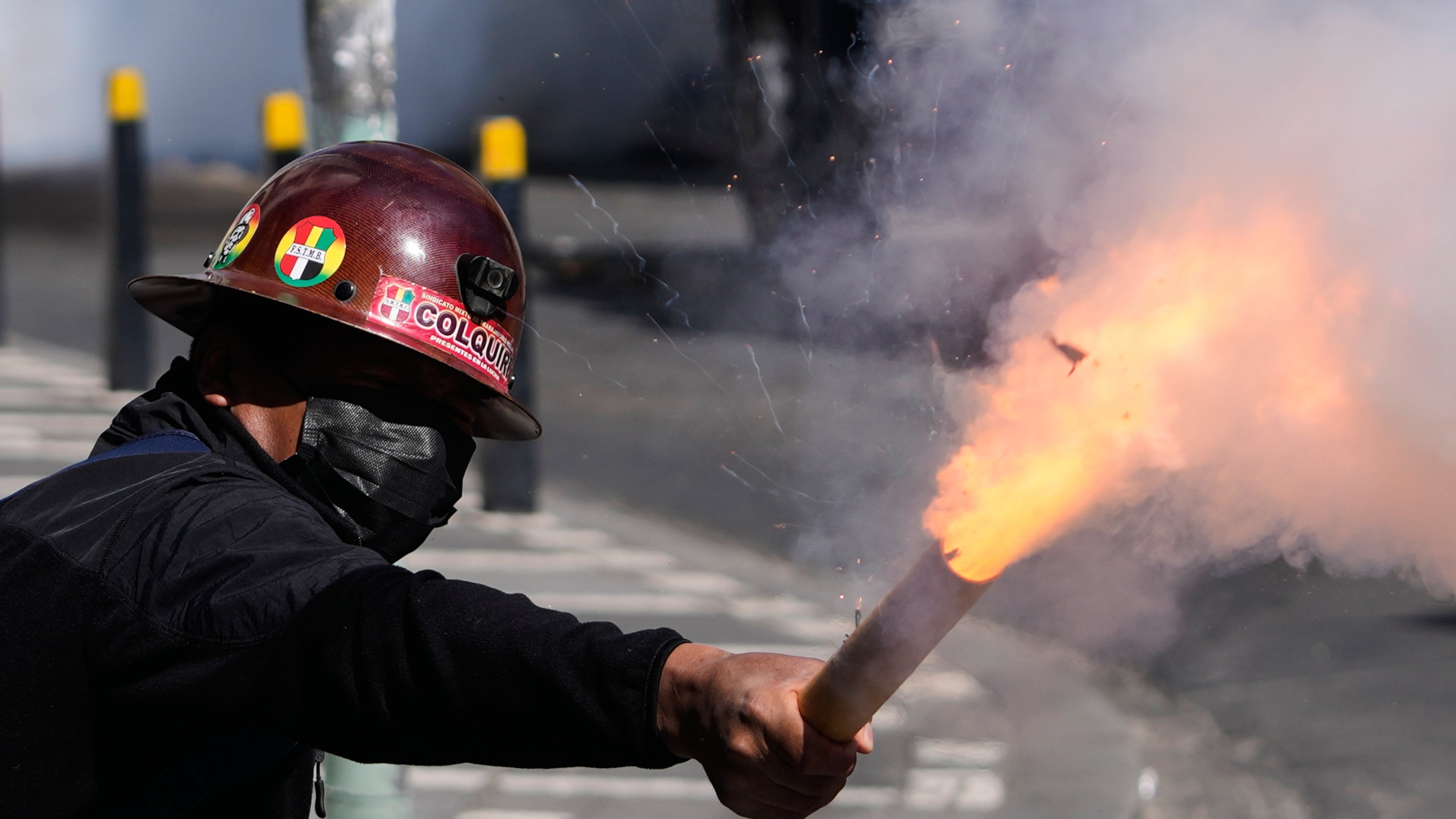 A miner launches a firecracker at police during an anti-government protest in La Paz, Bolivia, Monday, May 18, 2026. (AP Photo/Juan Karita)