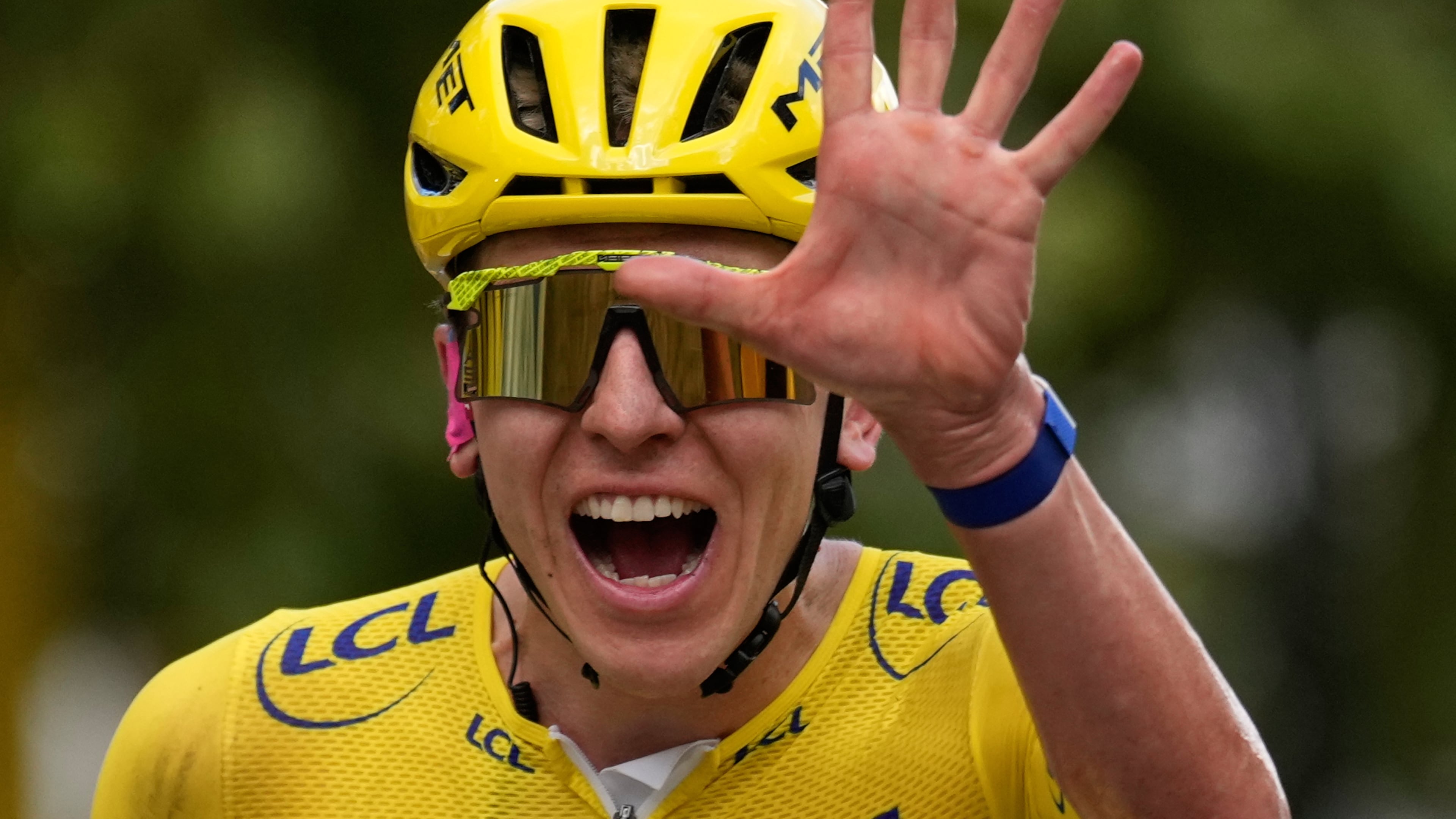 Slovenia's Tadej Pogacar, wearing the overall leader's yellow jersey, celebrates as he crosses the finish line of the last stage of the Tour de France cycling race with start and finish in Paris, Sunday, July 26, 2026. (AP Photo/Mosa'ab Elshamy)