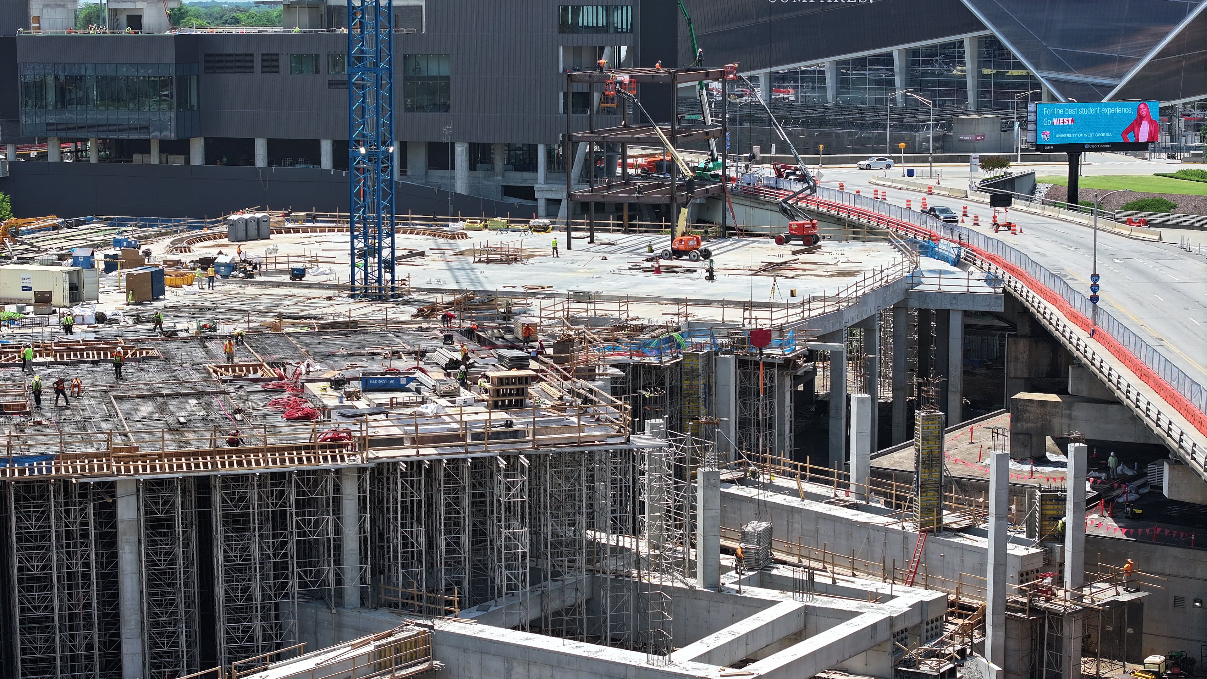 Photo shows new steel structure at Centennial Yards construction site during the Cosm Atlanta Steel Rising Ceremony, Thursday, May 15, 2025, in Atlanta. In the shadows of Mercedes-Benz Stadium and State Farm Arena, a new steel structure is rising, one that is expected to be the anchor of Centennial Yards. Construction started this week, but instead of a groundbreaking ceremony, since Centennial Yards is well underway, city and project officials had a “steel rising” ceremony Thursday. (Hyosub Shin/AJC)