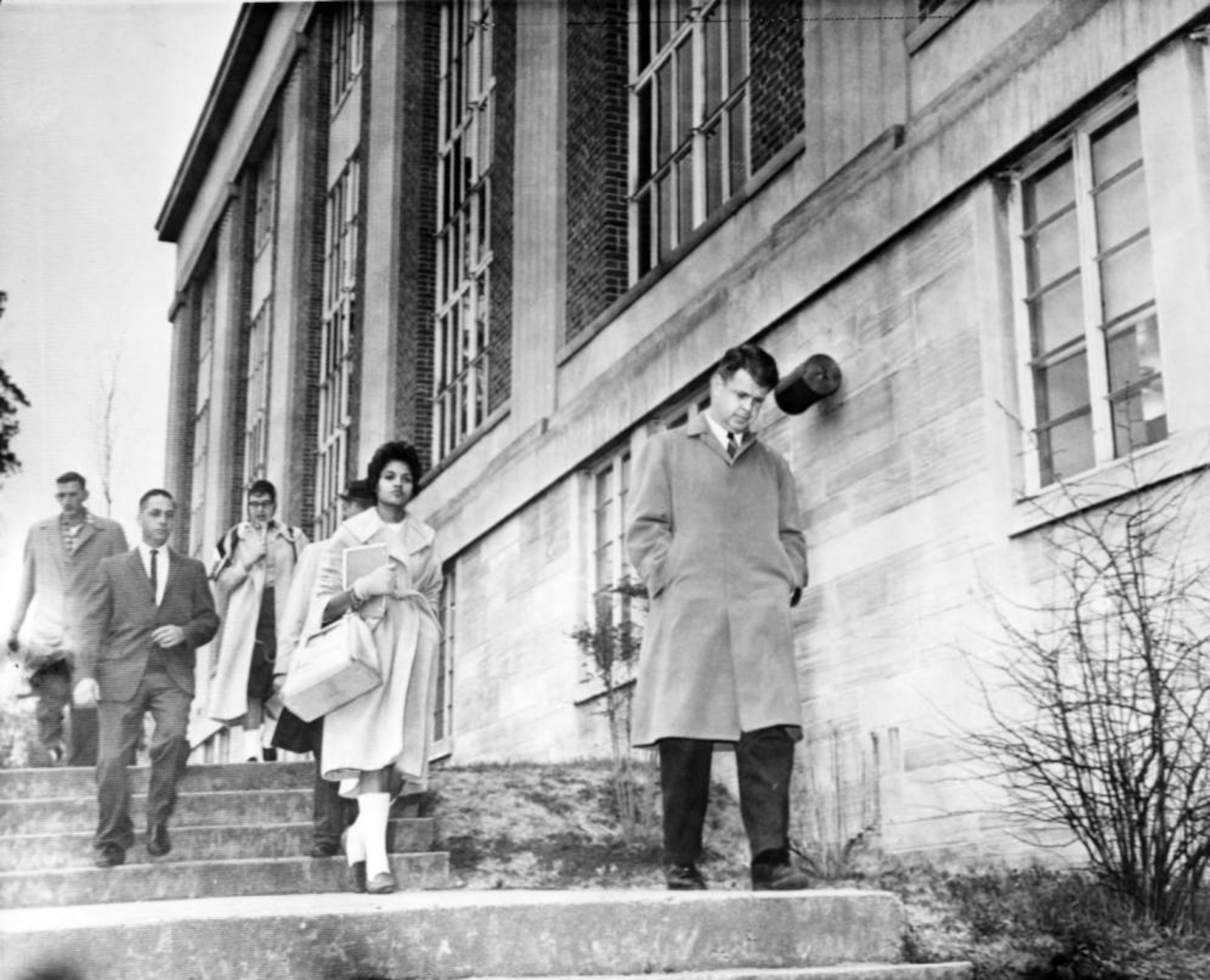 Charlayne Hunter, first of two African American undergraduate students admitted to the University of Georgia, is walked to class by campus officials, January 1961. Bill Young/AJC