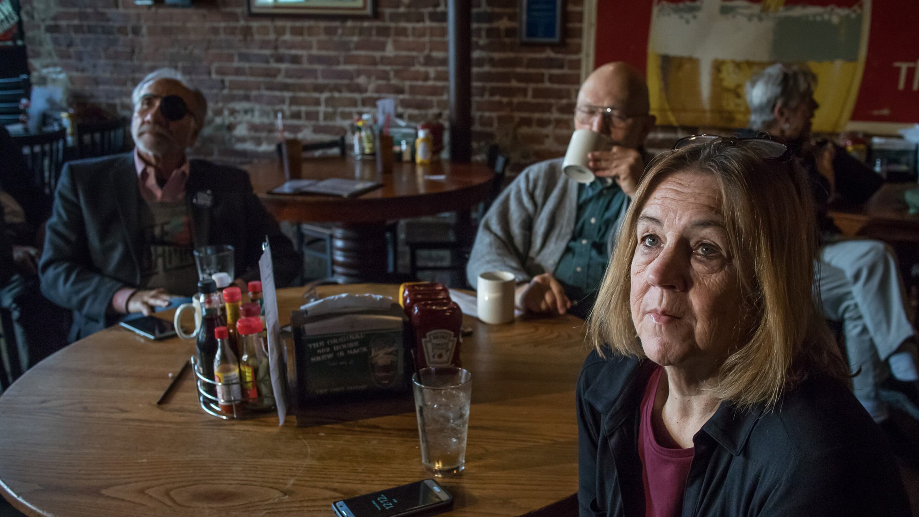 Helen Schroeder sits with her friends and watches Donald J. Trump’s inauguration on one of the many televisions at Manuel’s Tavern on Friday. STEVE SCHAEFER / SPECIAL TO THE AJC