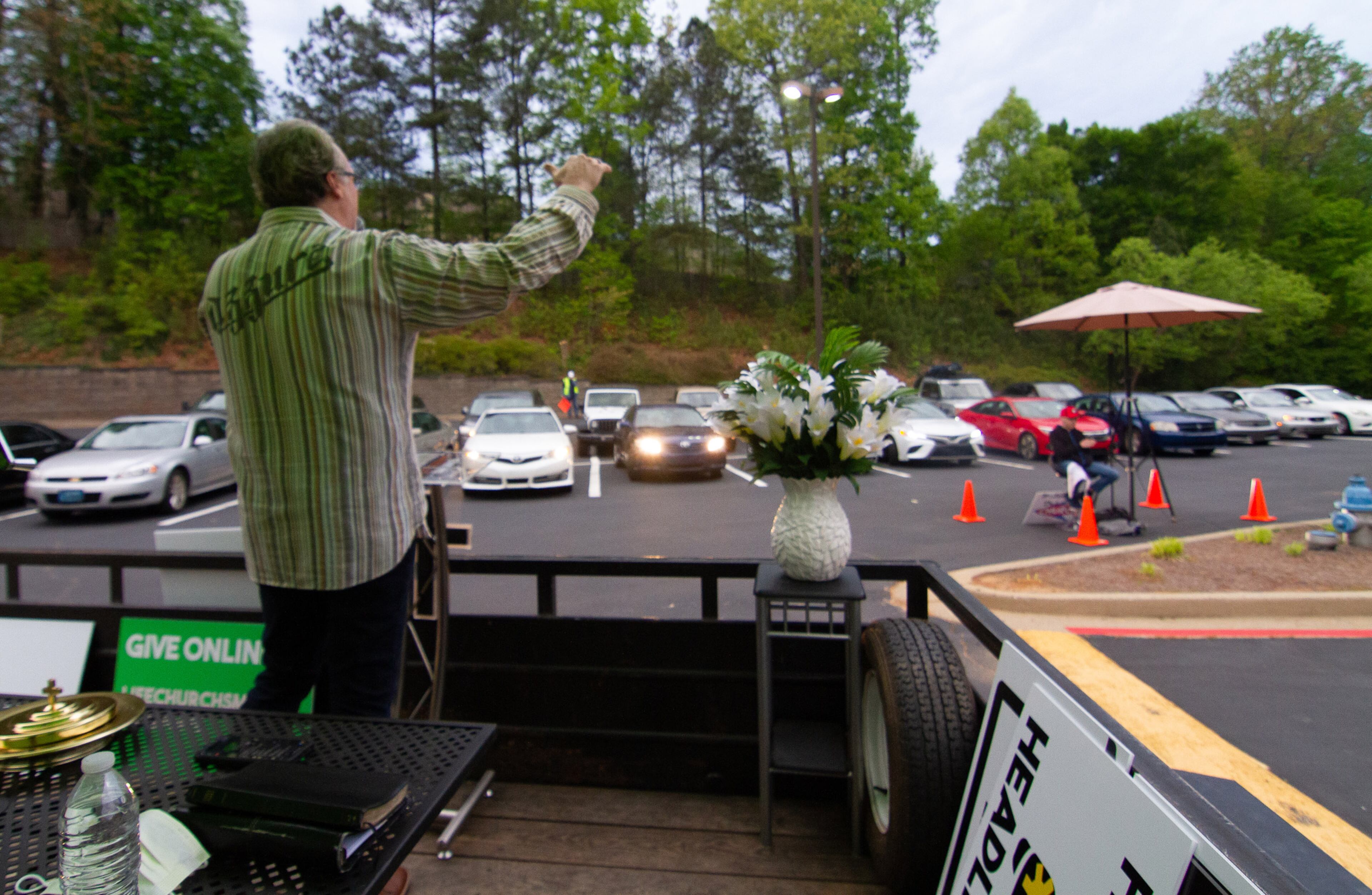 Pastor Shell Osbon, preaches to the people in their cars during the sunrise Easter Drive-in church service at the Life Church Smyrna Assembly of God Sunday in Smyrna April 12, 2020. STEVE SCHAEFER / SPECIAL TO THE AJC