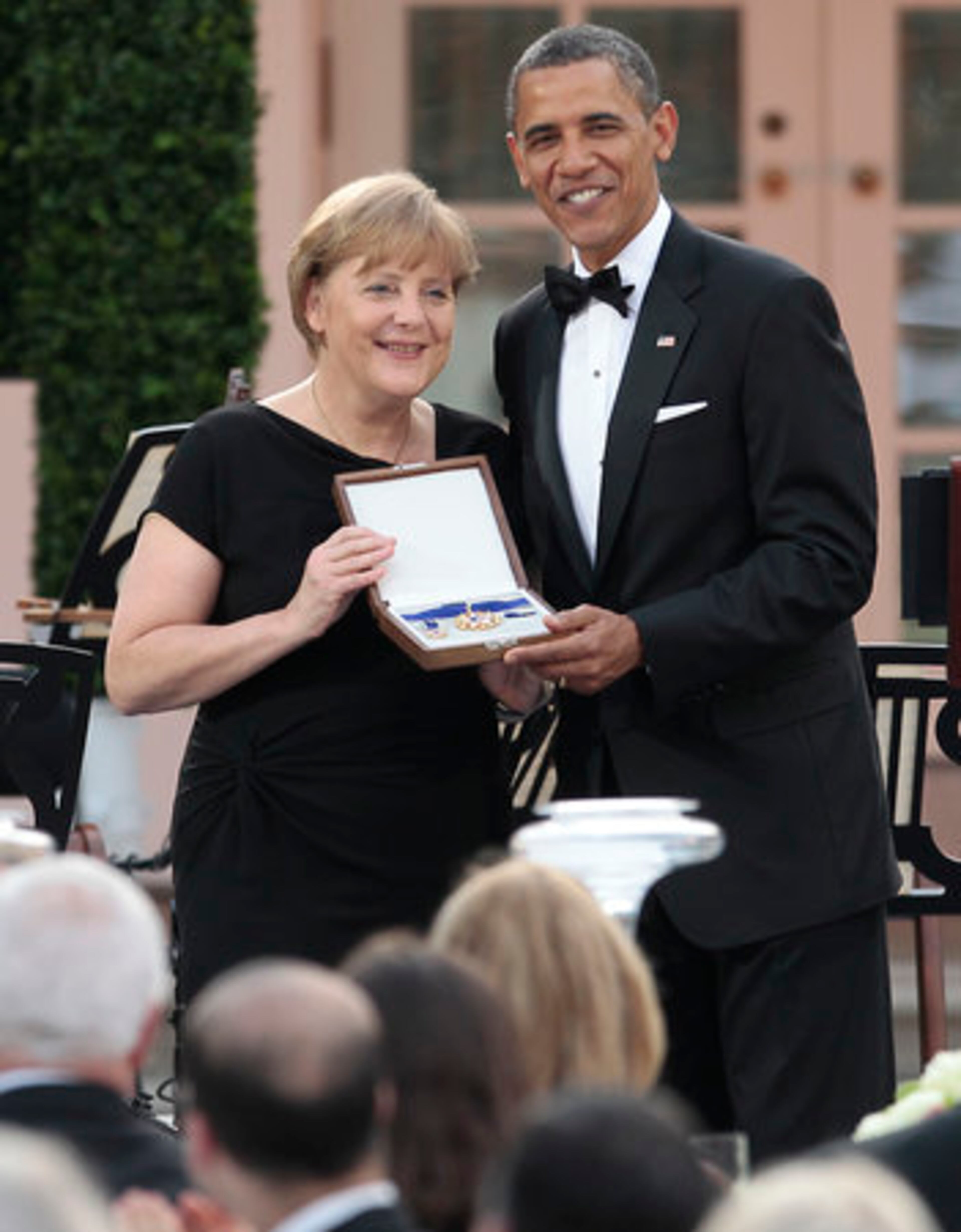 President Barack Obama presents German Chancellor Angela Merkel with the Medal of Freedom during the State Dinner in the Rose Garden of the White House in Washington, Tuesday, June 7, 2011.