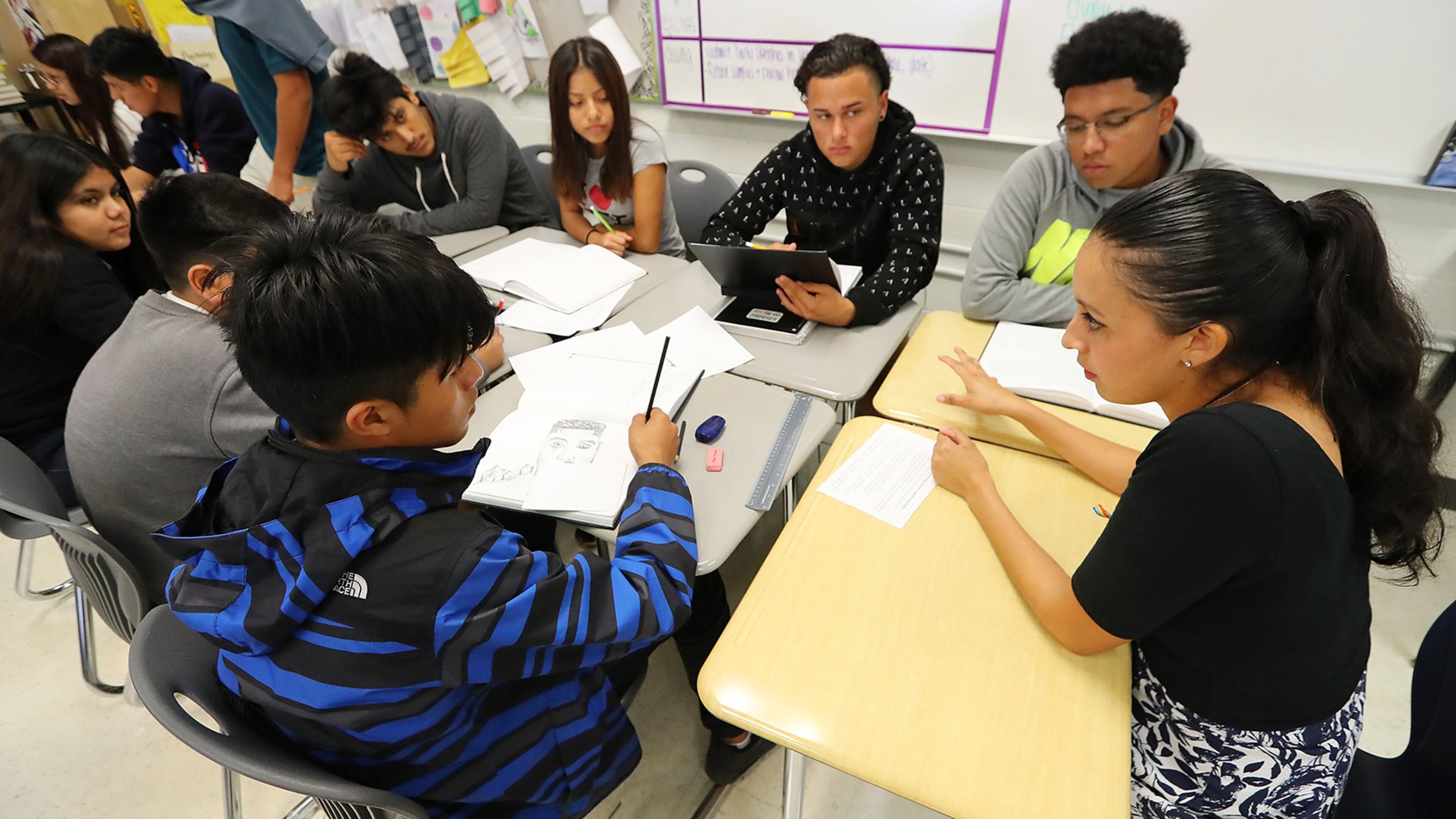Yehimi Cambrón (right) used to teach art at DeKalb's Cross Keys High School, where she's an alumna. Now, she's a full-time artist working on a master's degree in Chicago. Cambrón is undocumented and has temporary protection through a federal program called DACA. She hopes President Donald Trump doesn't decide to eliminate the program or decide to conduct immigration raids at schools, which his administration now has the authority to do. (Curtis Compton/AJC)