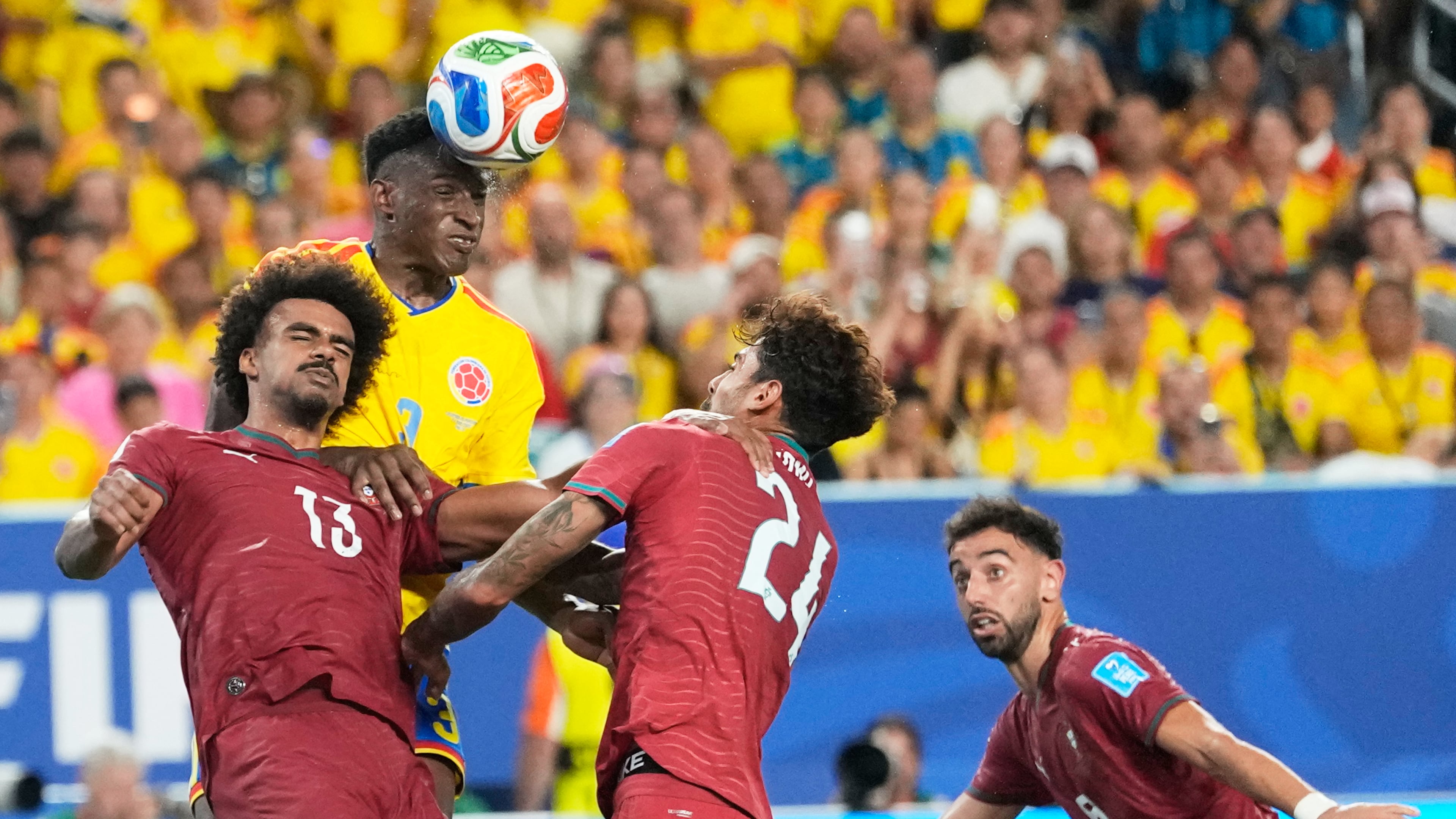 Colombia's Jhon Lucumi (3) leaps above Portugal's Renato Veiga (13) and Samu Costa (24) to head the ball during the World Cup Group K soccer match between Colombia and Portugal in Miami Gardens, Fla., Saturday, June 27, 2026. (AP Photo/Rebecca Blackwell)