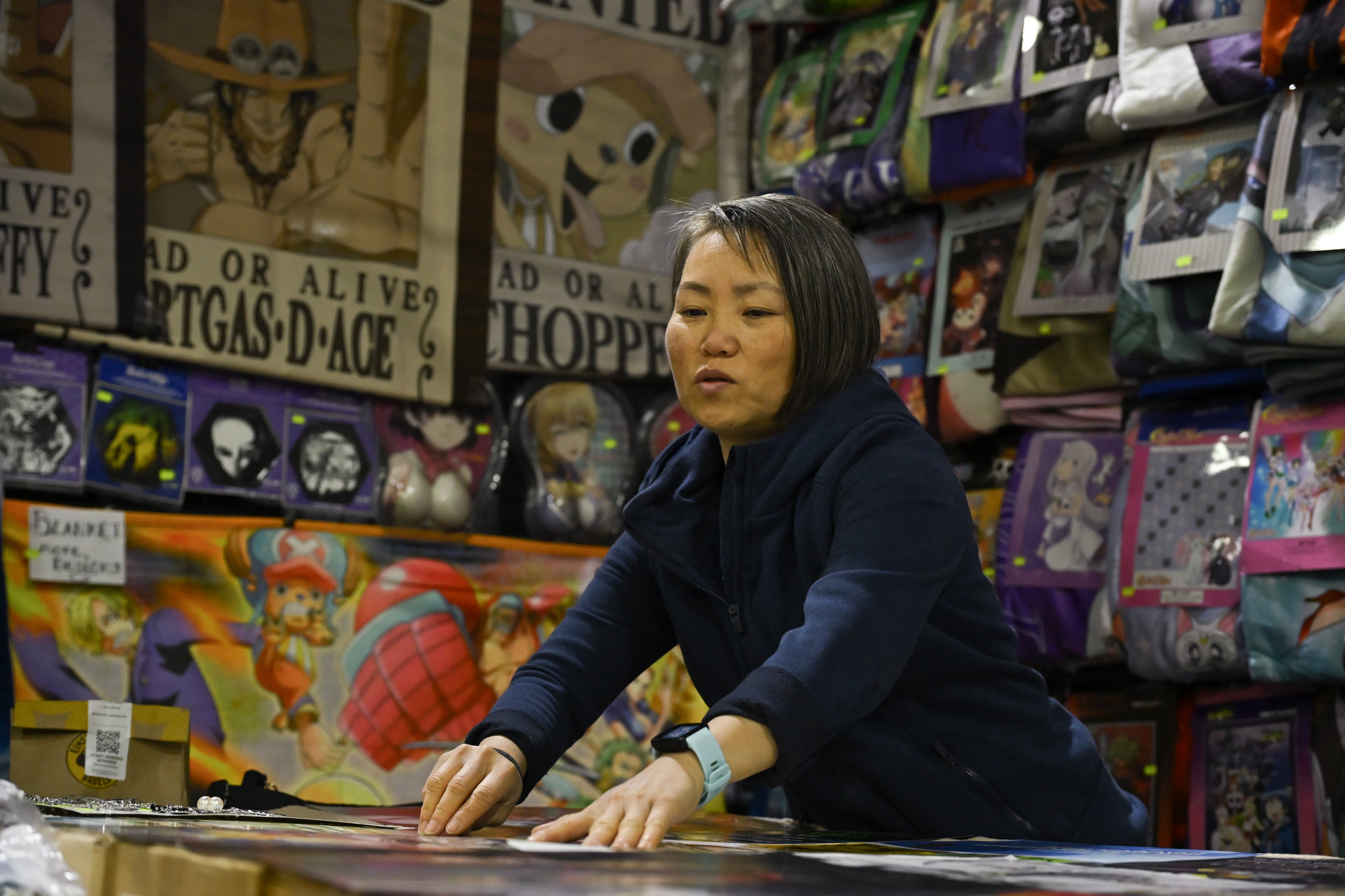A vendor prepares her booth during MomoCon at the Georgia World Congress Center in Atlanta on Friday, May 22, 2026. Organizers expect over 60,000 attendees. (Tyler Sun for the AJC)