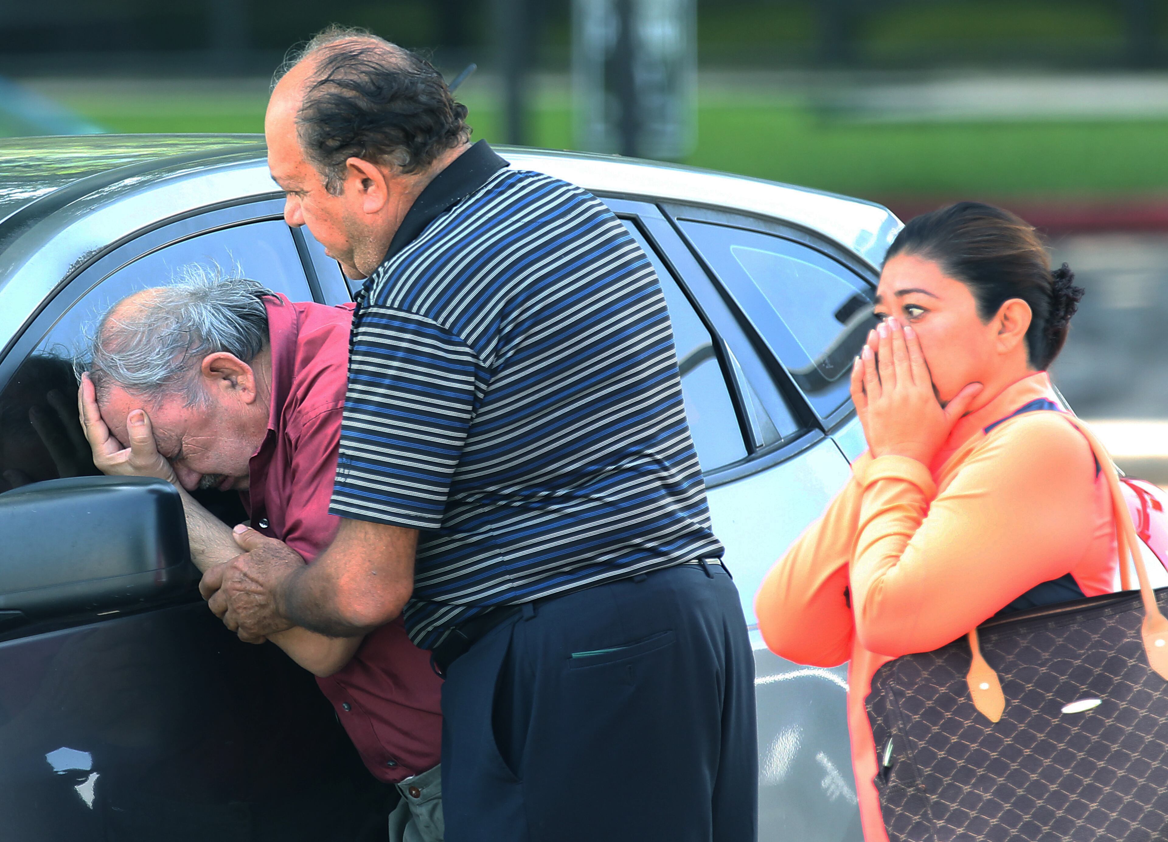 A man is comforted after finding out that a relative drowned in her truck at 5757 Ranchester in Houston on Tuesday, May 26, 2015. A holiday weekend of storms dumped record rainfall on the American heartland, caused major flooding and spawned tornadoes. More than 1,000 homes have been damaged or destroyed in Texas, and thousands of residents are displaced. (Thomas B. Shea/Houston Chronicle via AP)