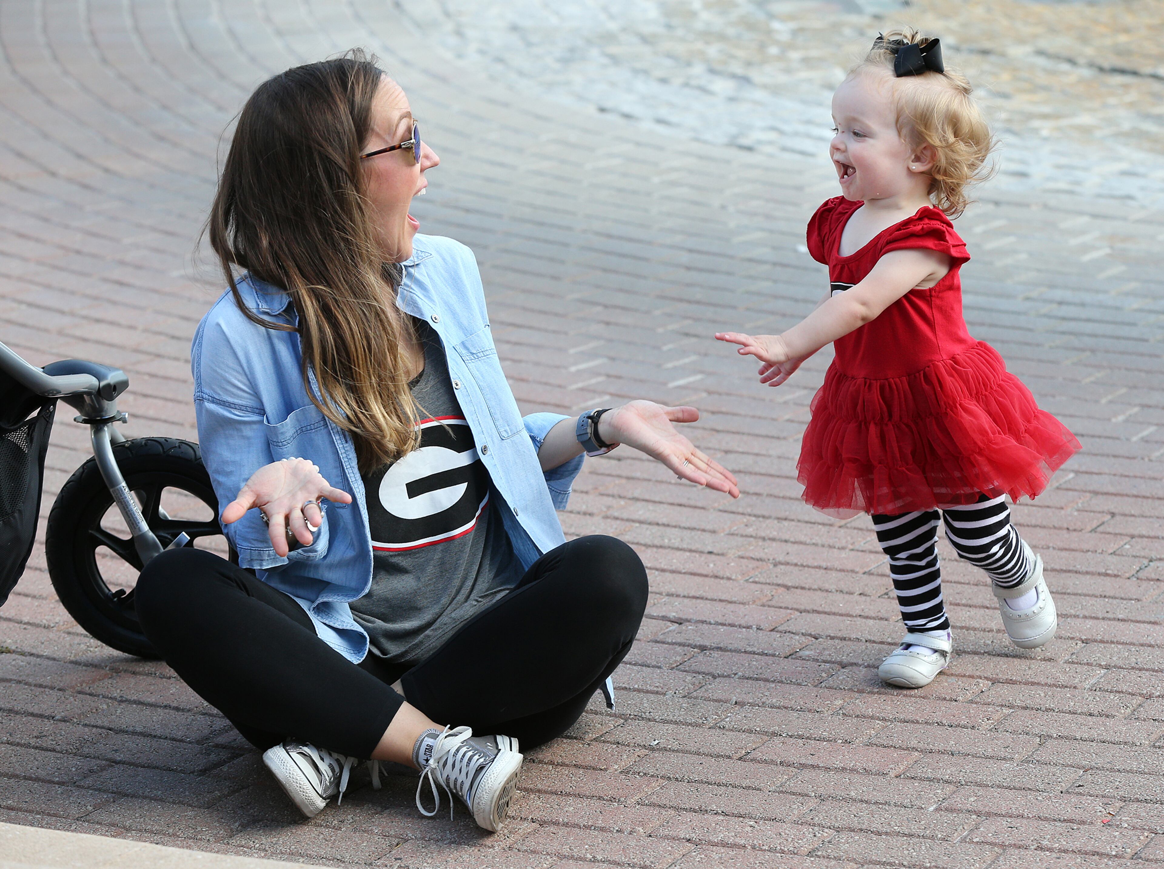 Georgia fan Meghan Scott reacts as her daughter Harper, 1, dances to the music during the GA/FL Celebration at the Jacksonville Landing the night before the Georgia vs Florida NCAA college football game on Friday, Oct 26, 2018, in Jacksonville. Curtis Compton/ccompton@ajc.com