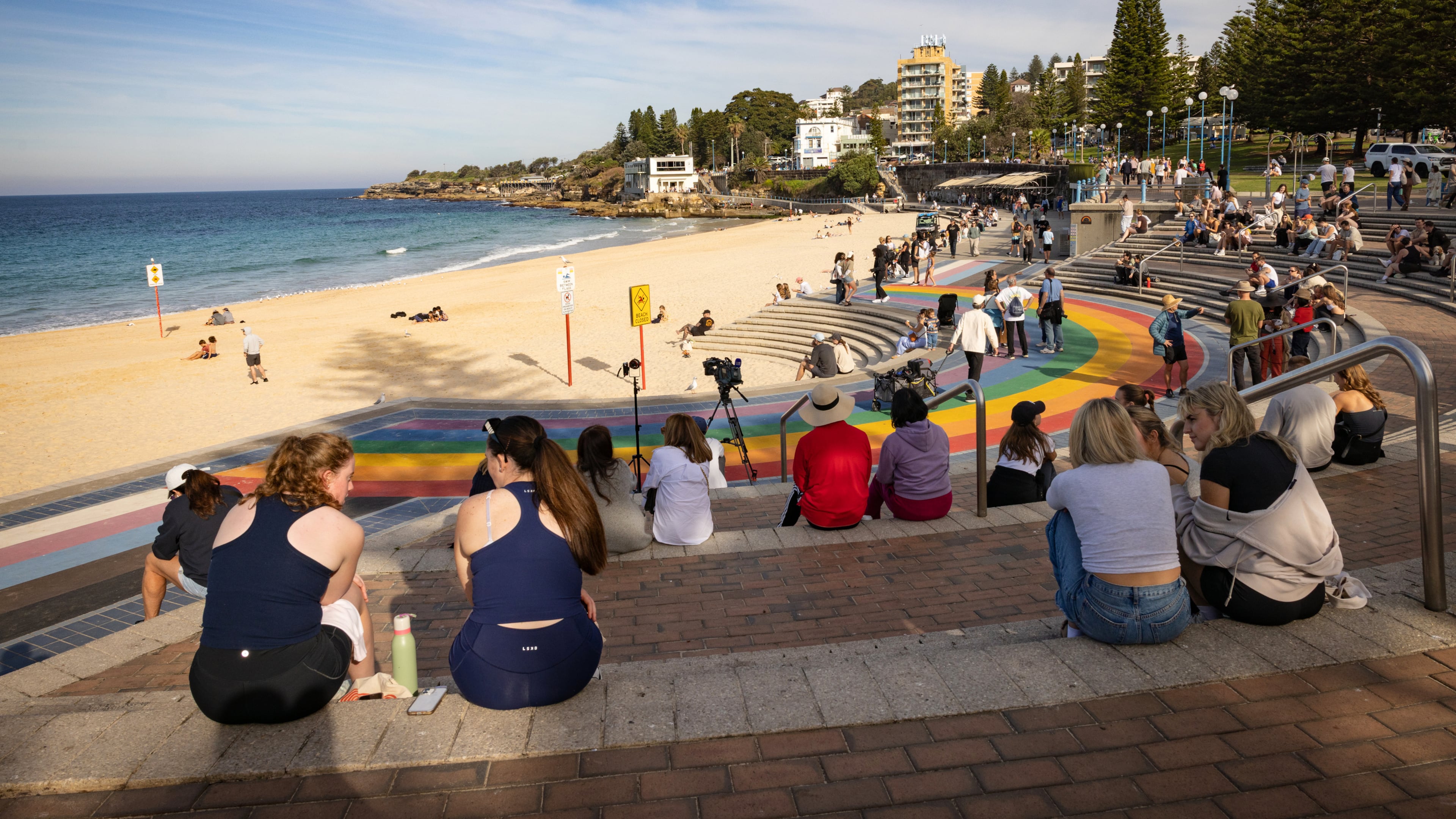 People sit on stairs at Coogee beach following a shark attack in Sydney, Saturday, June 13, 2026. (Nadir Kinani/AAP Image via AP)