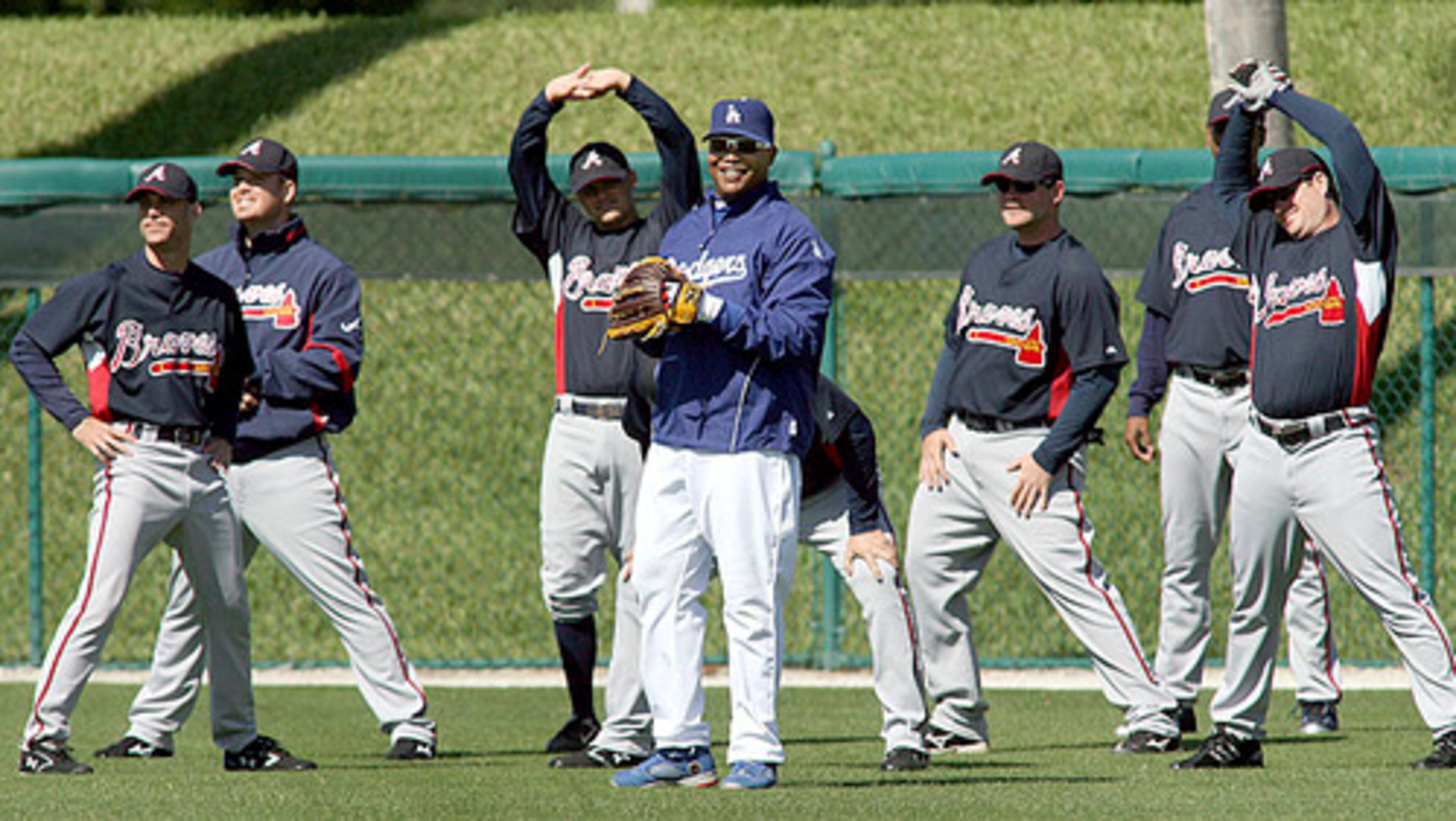 Former Brave Andruw Jones still fits in with the Braves as his former team takes part in stretching exercises as the Dodger outfielder catches fly balls before their spring training game at Hollman Stadium in Vero Beach.