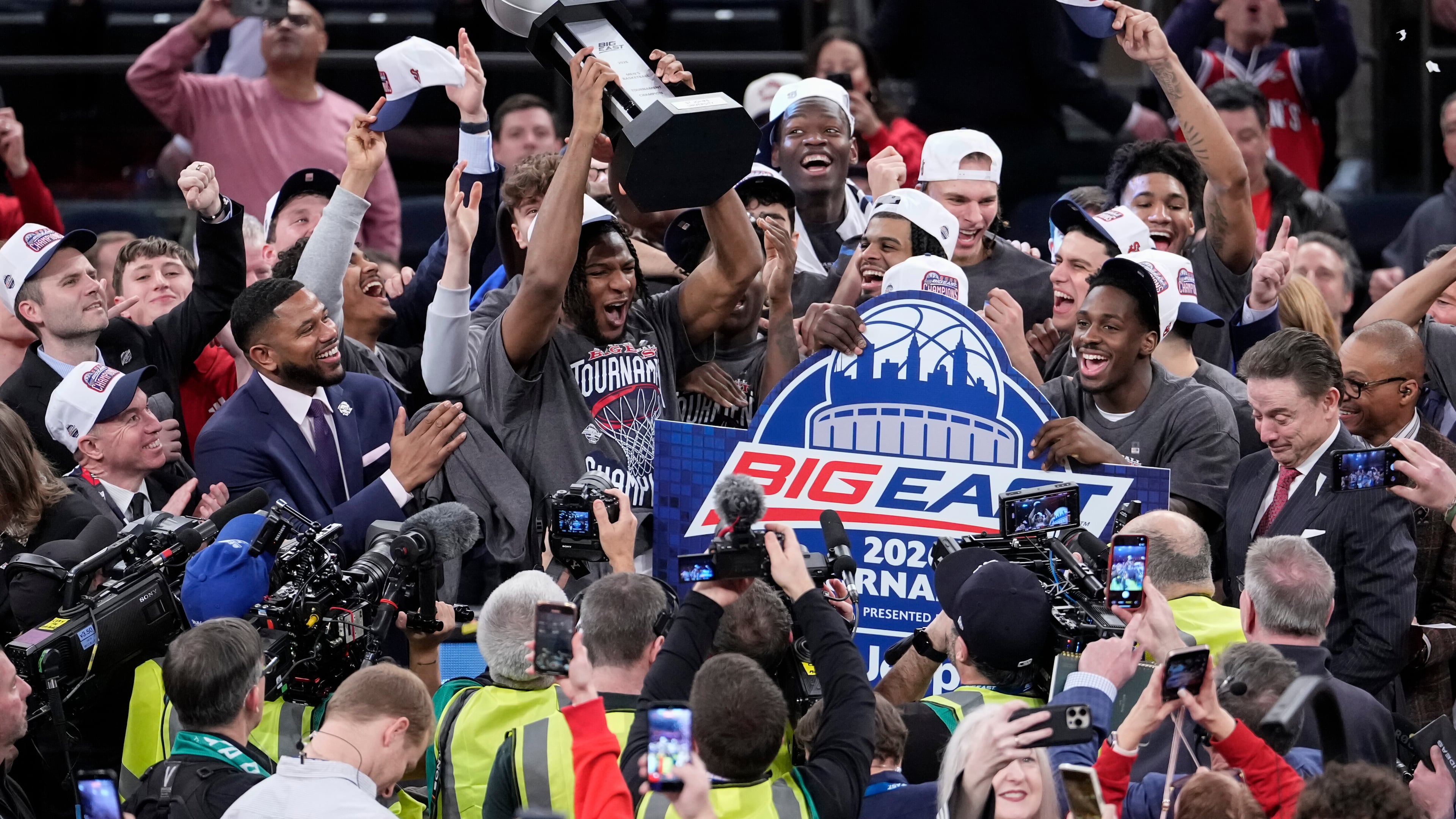St. John's forward Zuby Ejiofor and players of St. John's raise a tournament trophy after an NCAA college basketball game against UConn in the championship of the Big East tournament, Saturday, March 14, 2026, in New York. (AP Photo/Yuki Iwamura)