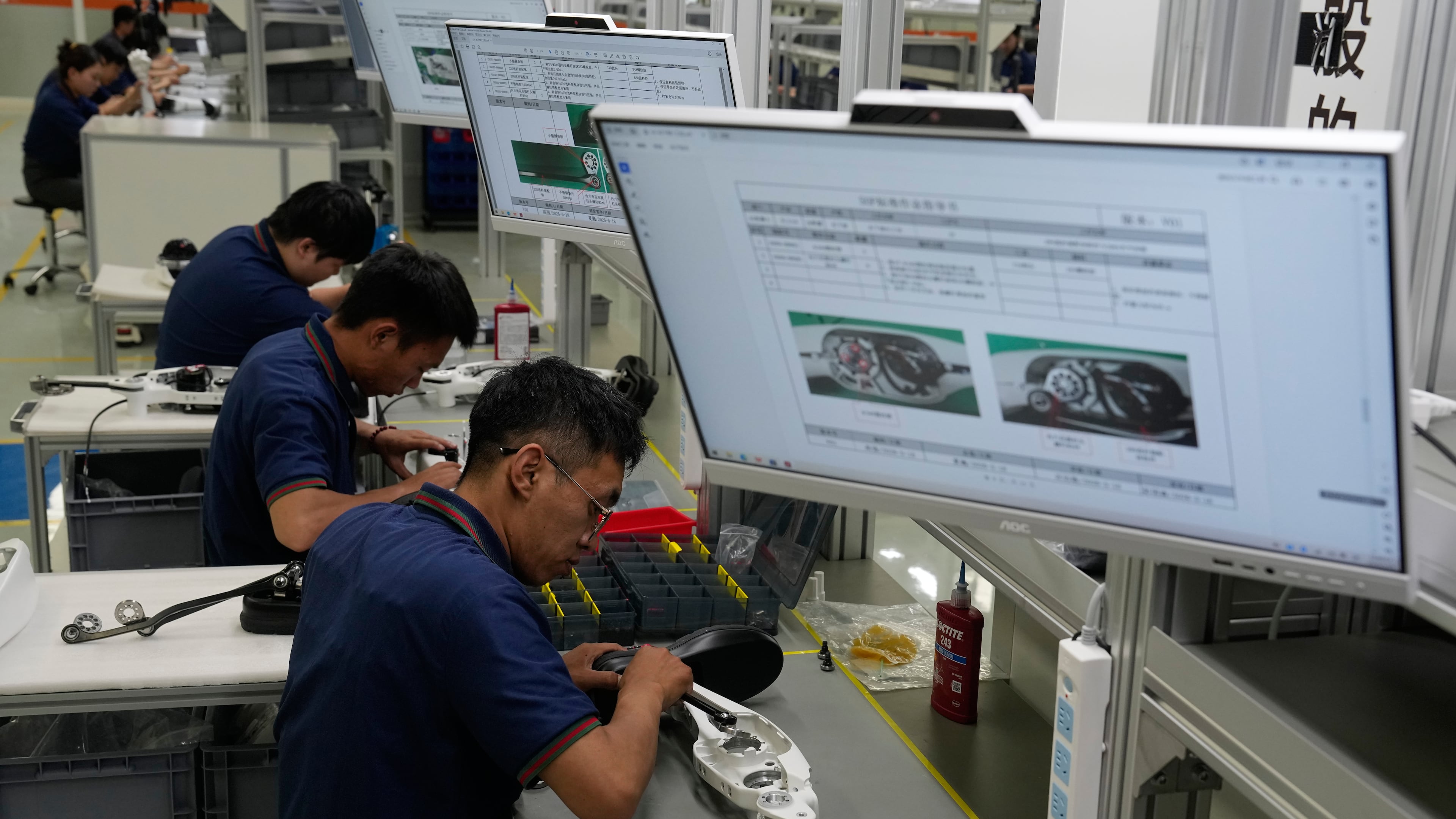 Workers assemble robot legs components at the LY iTech Beijing Super Factory for Embodied Artificial Intelligence during a media tour in the Beijing E-Town on the outskirts of Beijing on May 29, 2026. (AP Photo/Andy Wong)