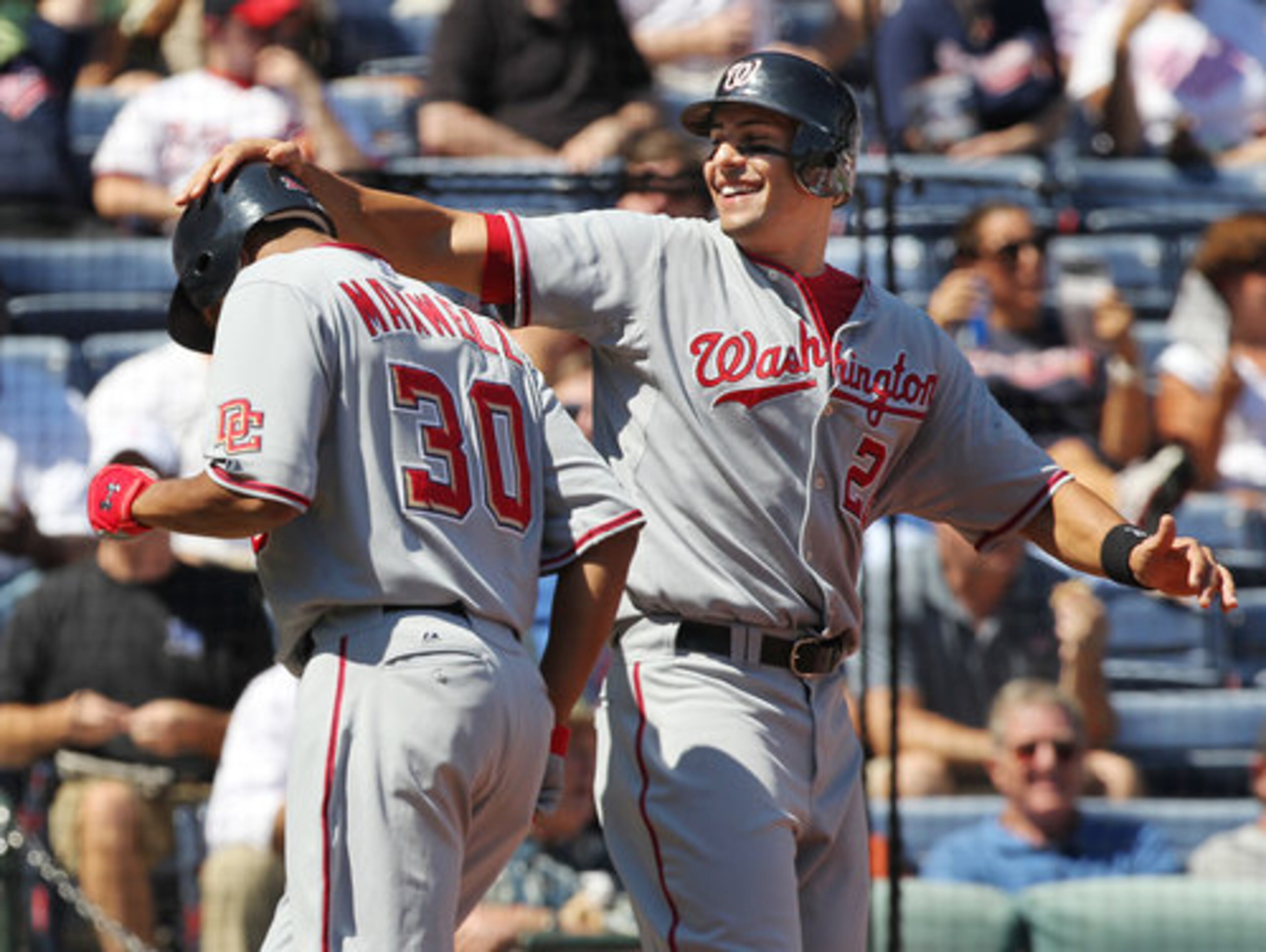 Washington Nationals Justin Maxwell, left, gets a hard pat on the helmet from Mike Morse, right, as he crosses homeplate hitting a grand slam for a 4-0 lead over the Atlanta Braves during 2nd inning action at Turner Field in Atlanta on Wednesday, Sept. 15, 2010. The Nationals beat the Braves 4-2.