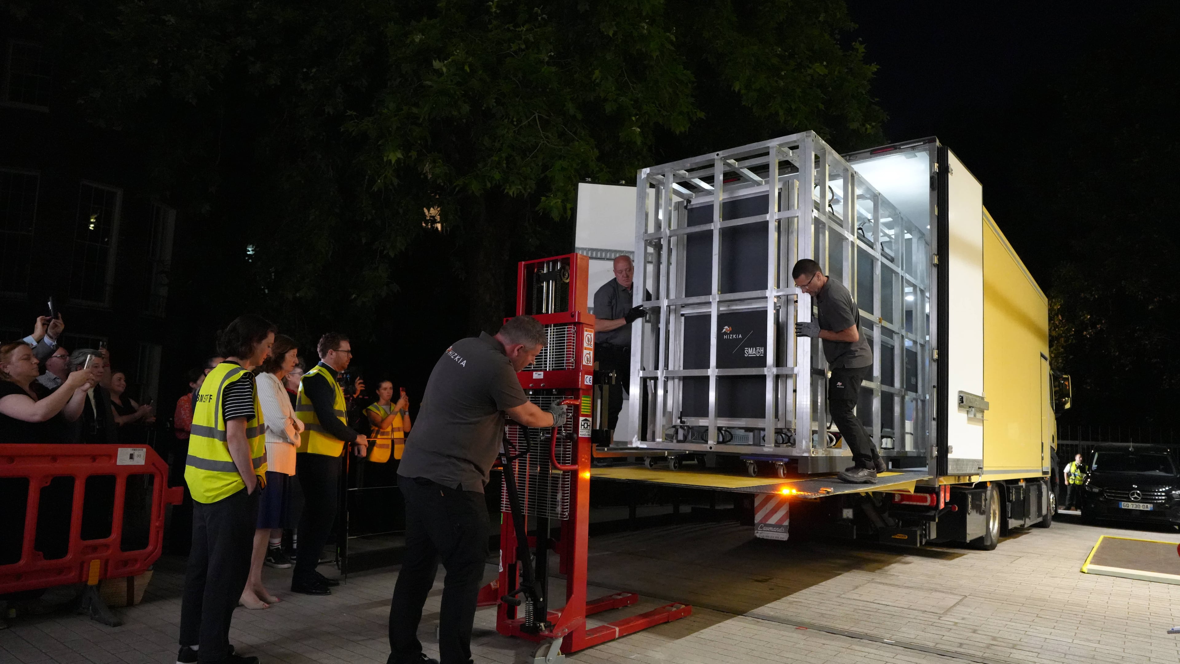 Workers unload a box that contains the Bayeux Tapestry out of a truck at the British Museum in London, Friday, July 10, 2026. (AP Photo/Kwiyeon Ha)
