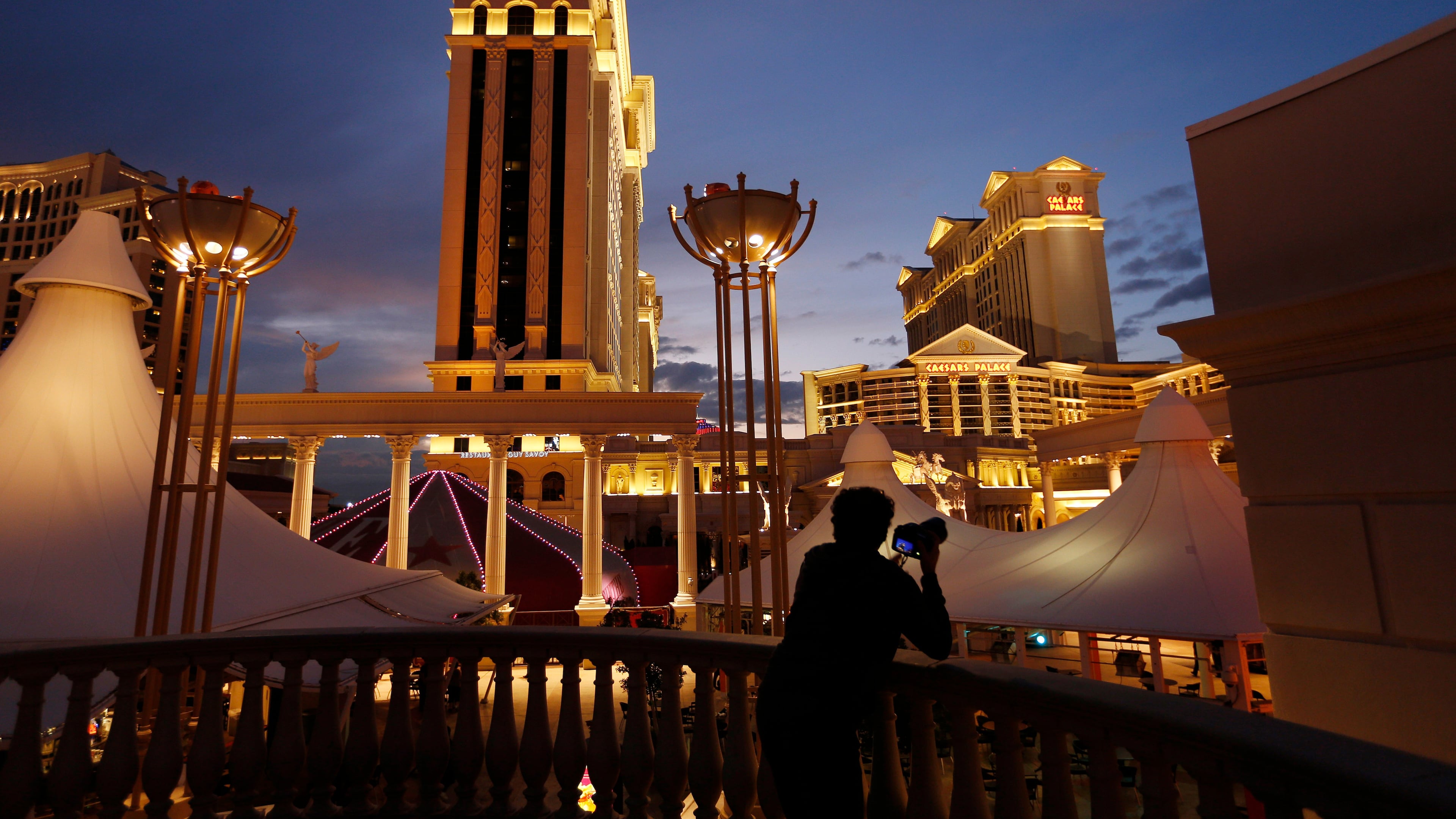 FILE - A man takes pictures of Caesars Palace hotel and casino in Las Vegas, Jan. 12, 2015. (AP Photo/John Locher, File)