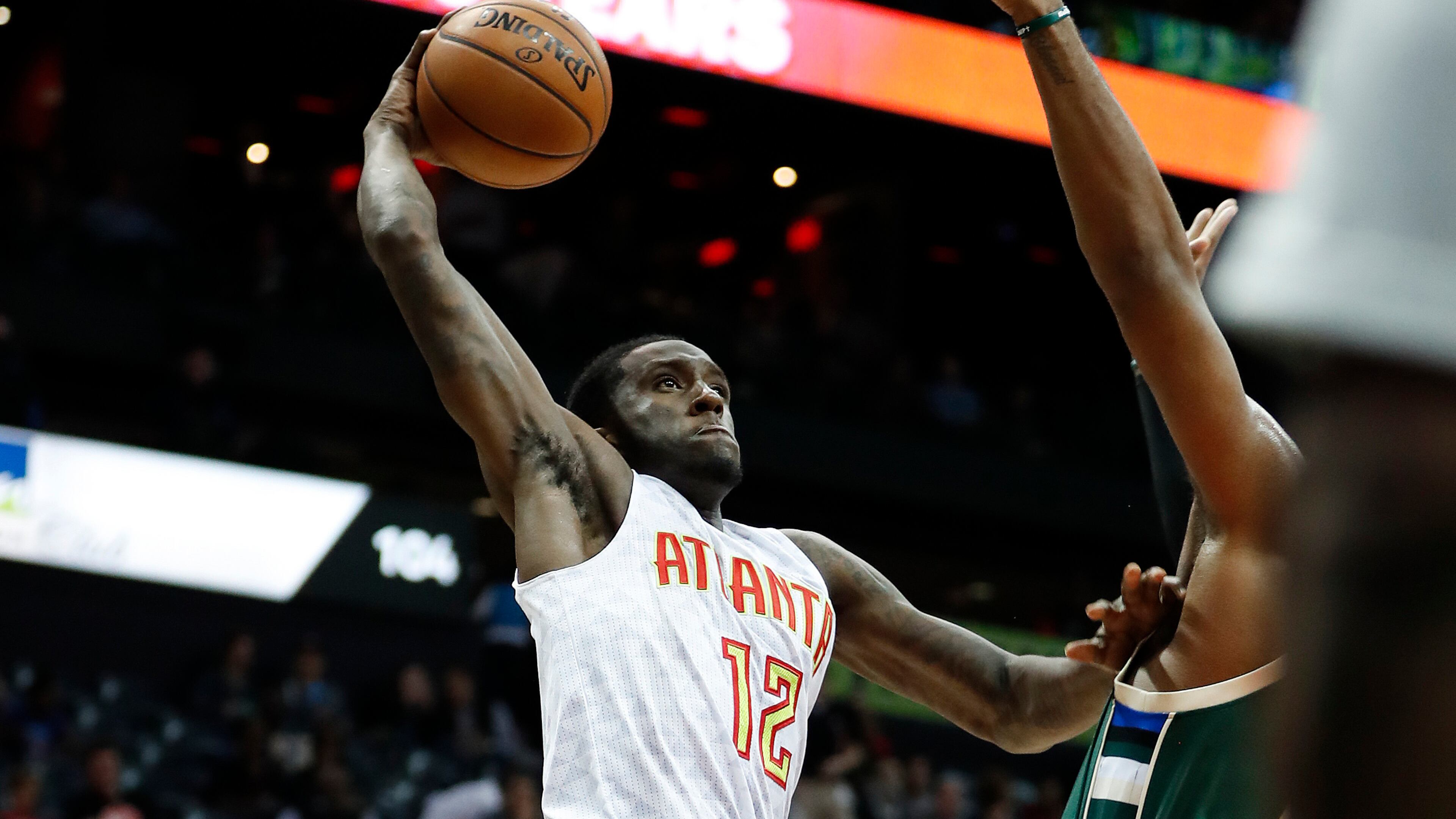 Atlanta Hawks forward Taurean Prince (12) scores against Milwaukee Bucks center Greg Monroe (15) in the first half of an NBA basketball game Wednesday, Nov. 16, 2016, in Atlanta. (AP Photo/John Bazemore)