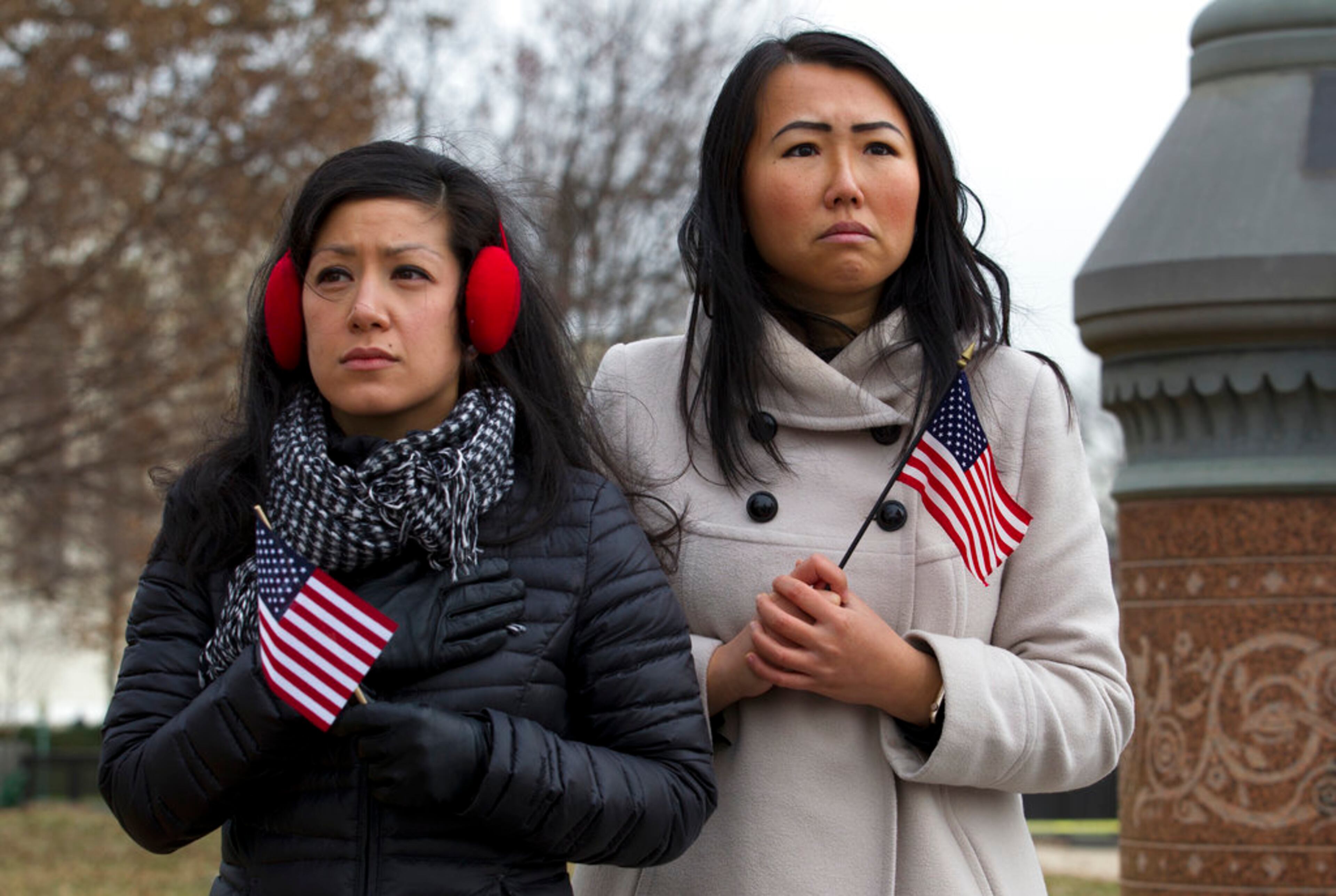 Stephanie Penn, left, and Tiffany Ge watch the flag-draped casket of former President George H. W. Bush carried by a joint services military honor guard down the steps of the U.S. Capitol, Wednesday, Dec. 5, 2018, in Washington. (AP Photo/Jose Luis Magana)