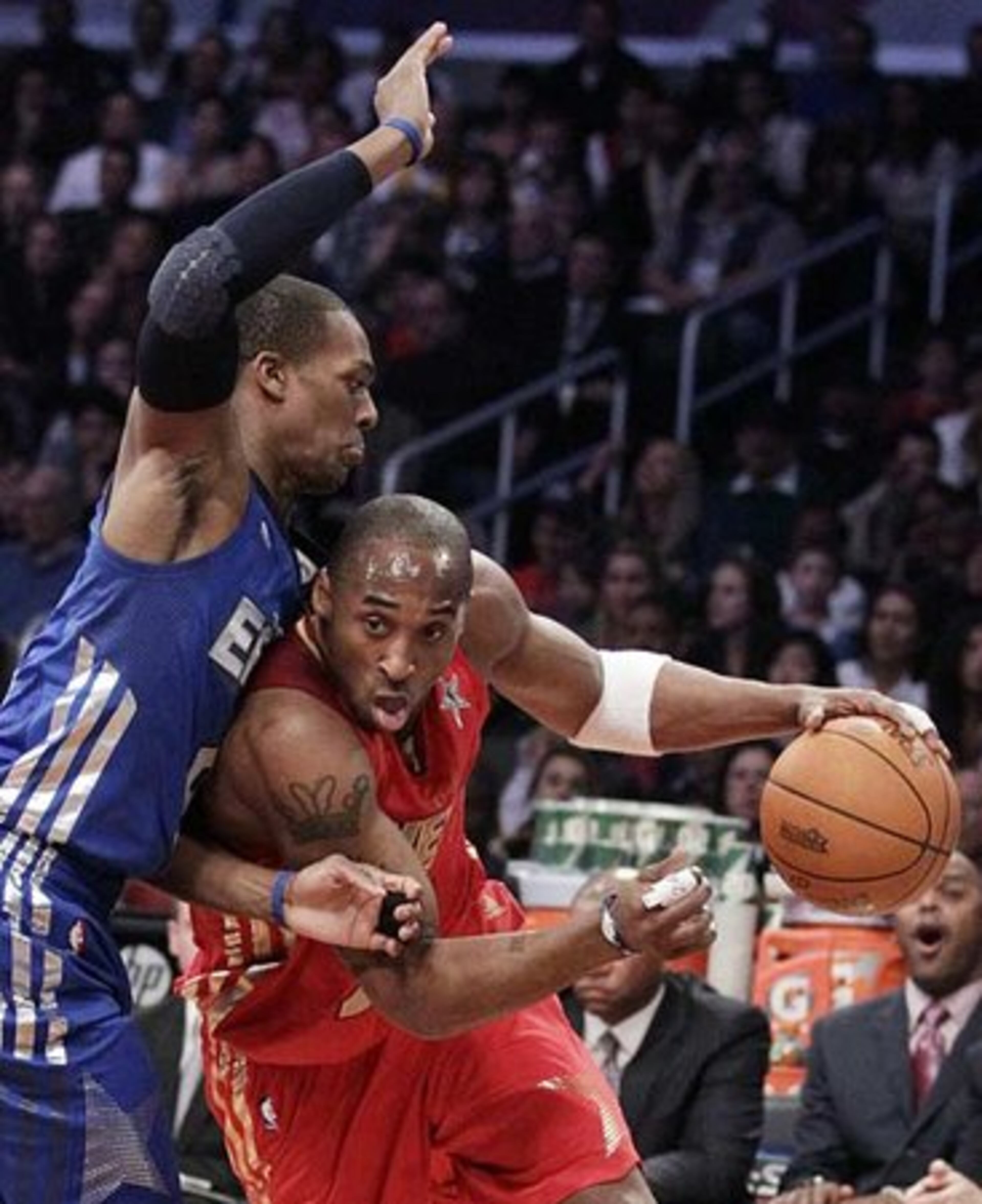 West's Kobe Bryant, of the Los Angeles Lakers, is closely guarded by East's Rajon Rondo, of the Boston Celtics.