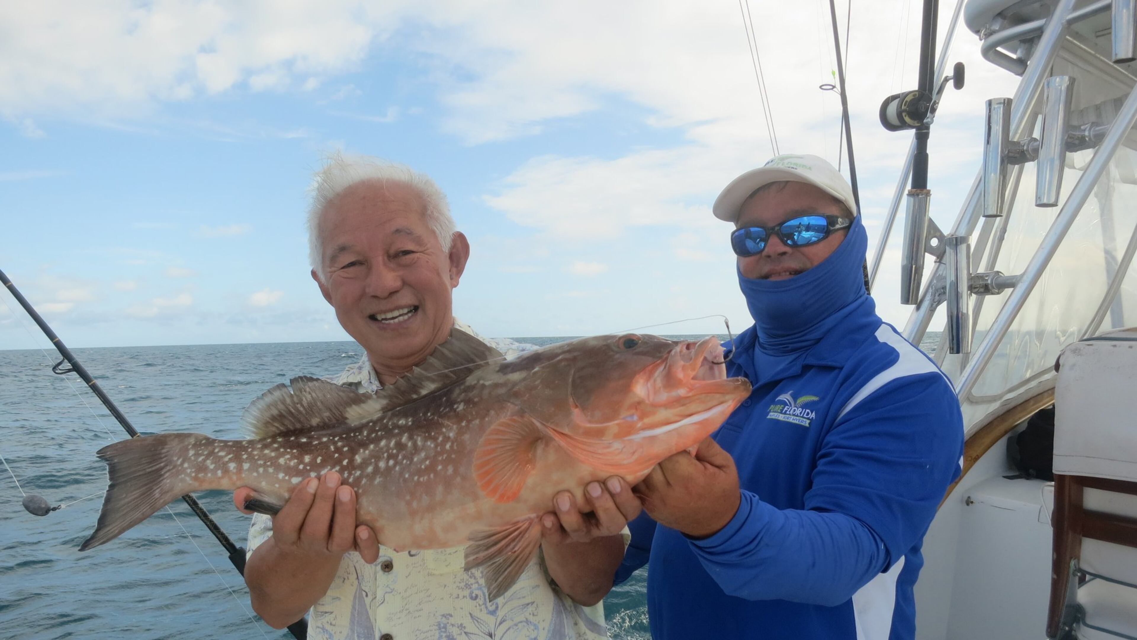 Capt. Jason Gilbert of Pure Florida (right) with a deep sea fisherman showing off a catch. (Tracey Teo)