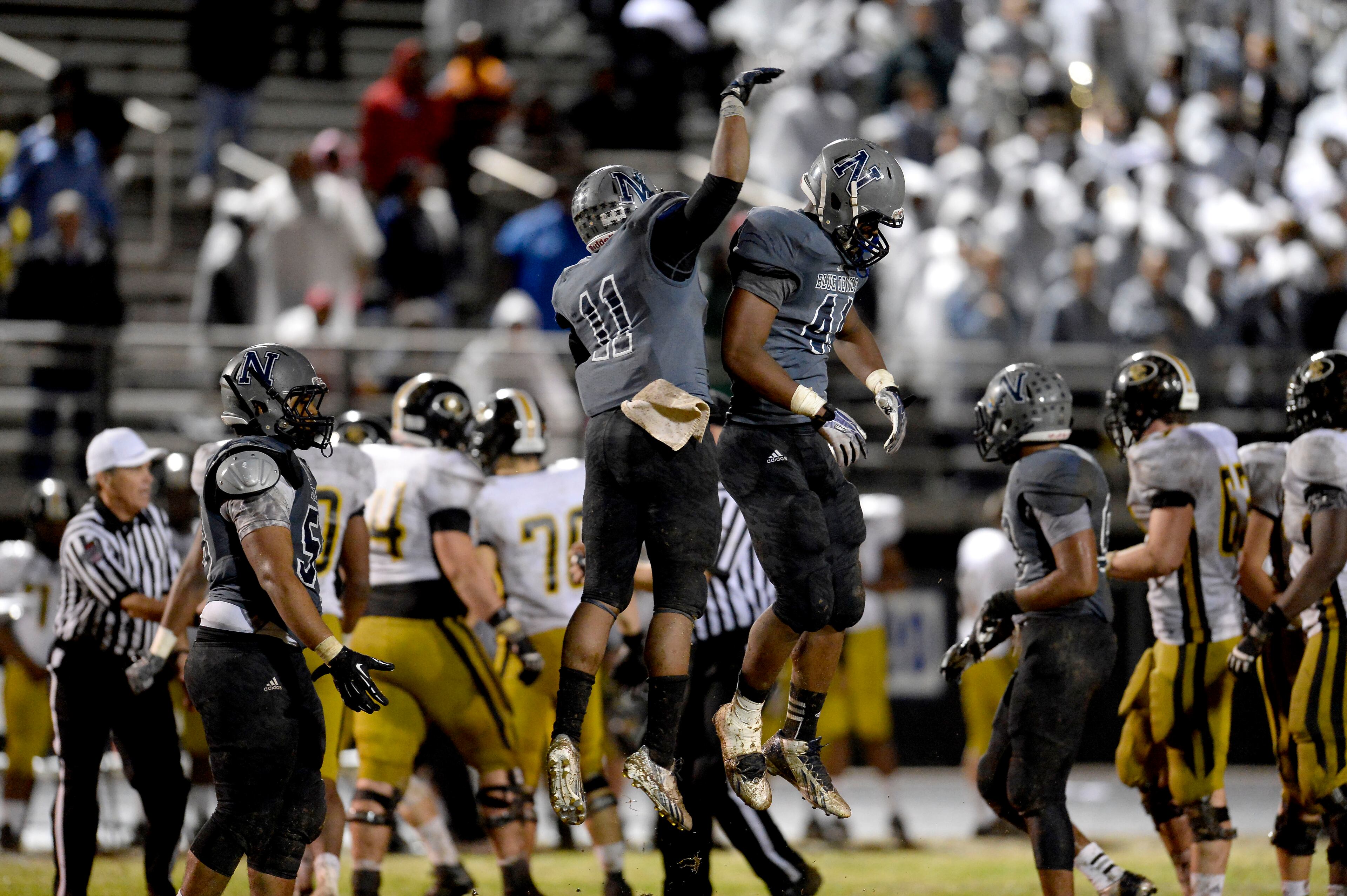 Norcross's Jaquan Frazier (11) and Isaiah Gates (41) celebrate a defensive stop against Colquitt County late in the fourth quarter of their AAAAAA semifinal game at Blue Devil Stadium on Friday, Dec. 6, 2013, in Norcross, Ga.