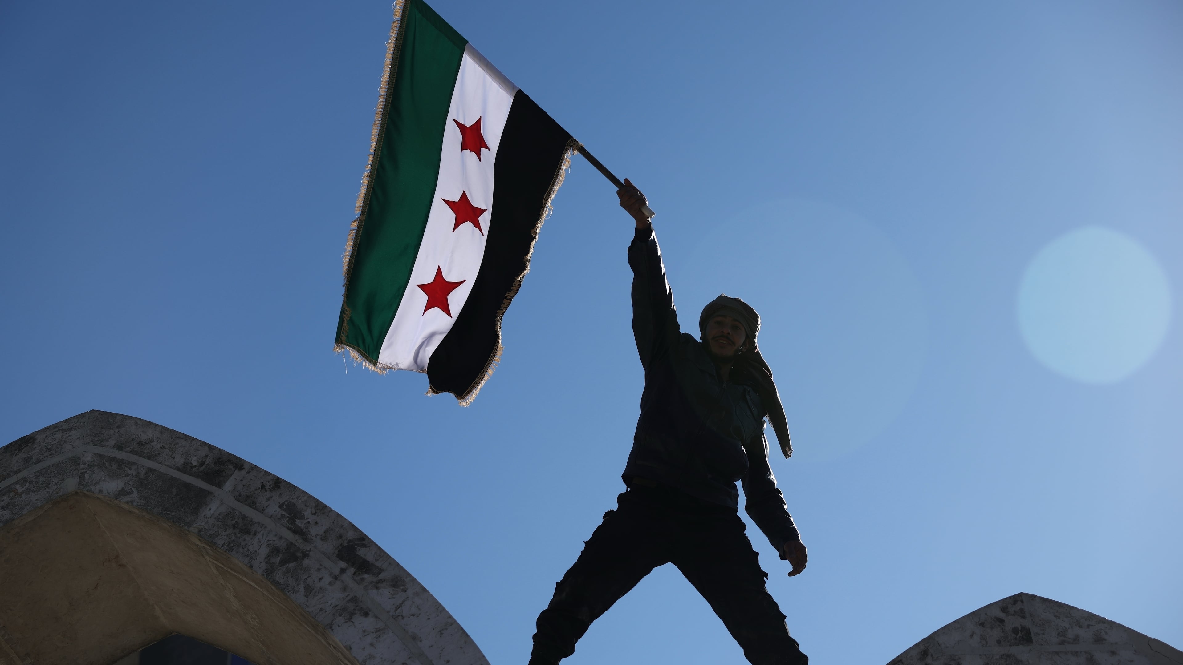 FILE - A soldier waves a Syrian flag amid celebrations a day after Syrian government troops took control of Raqqa from the Syrian Democratic Forces (SDF), at Al-Naeem roundabout in central Raqqa, northeastern Syria, Monday, Jan. 19, 2026. (AP Photo/Ghaith Alsayed, File)