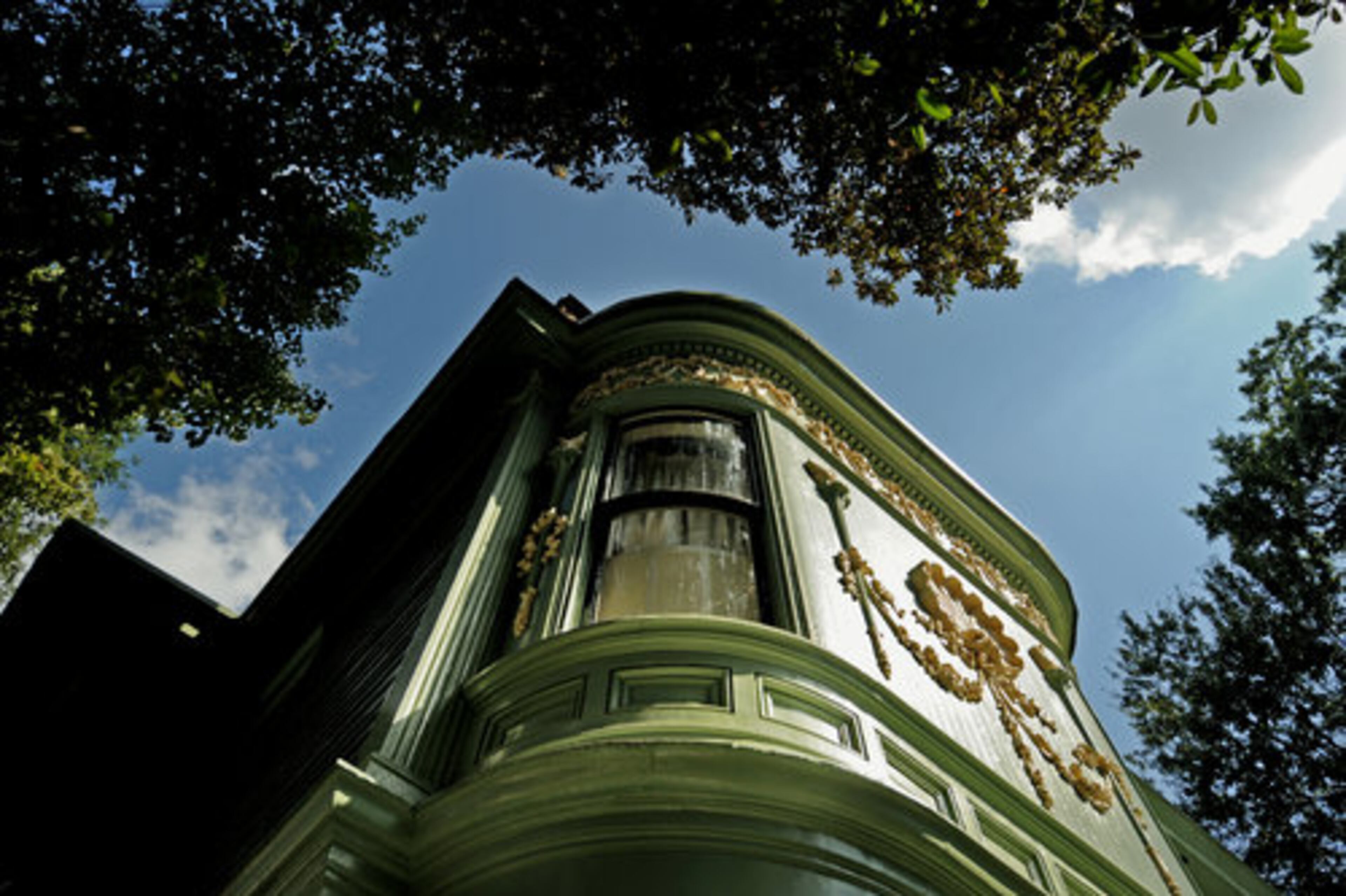 The home features curved glass panels. Benign neglect and some poor maintenance meant the house came with significant problems. There were seven roofs piled one on top of the other and plaster ceilings that crashed to the floor on the day the couple closed on the house.