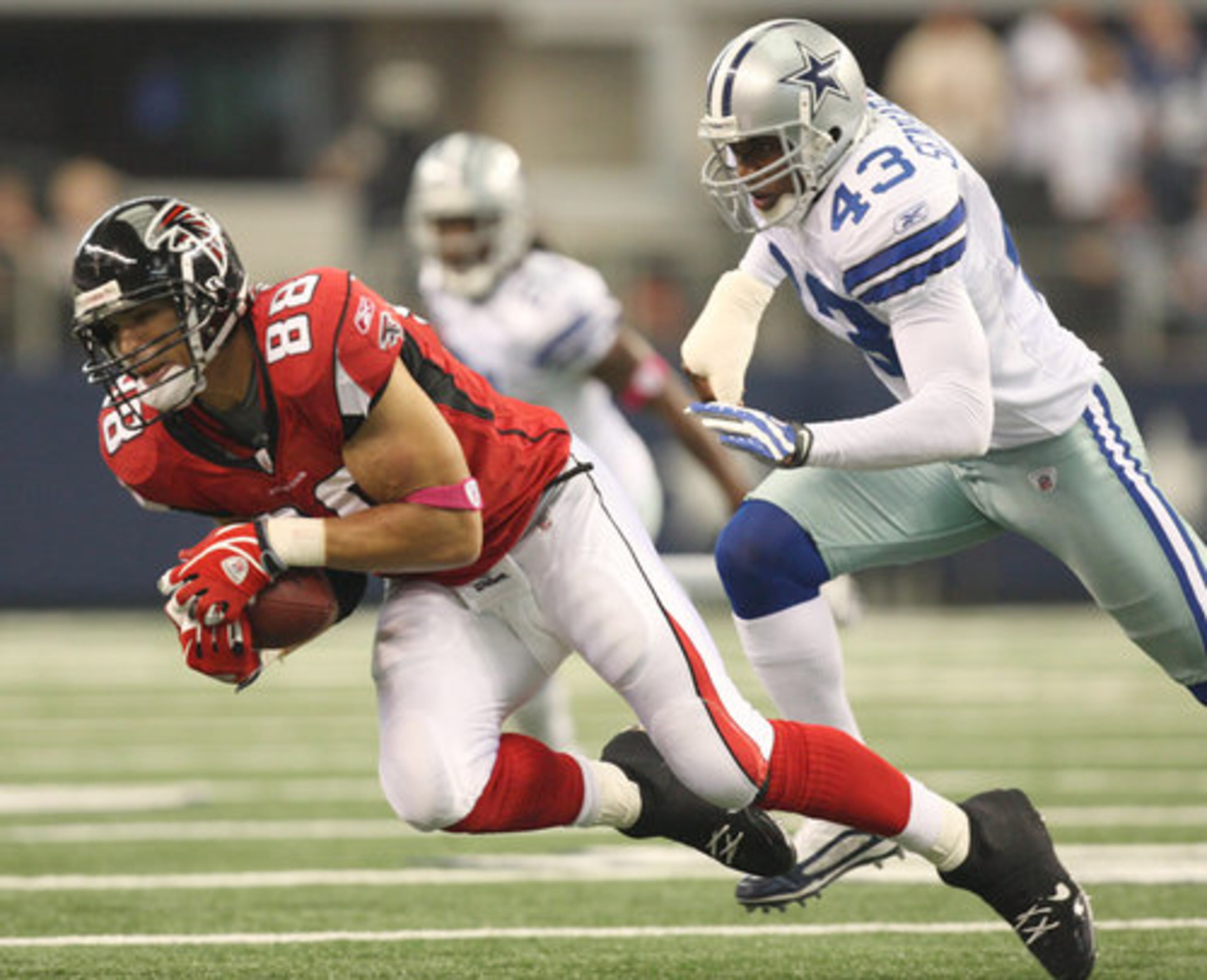 Cowboys safety Gerald Sensabaugh (43) chases after Falcons tight end Tony Gonzales following a catch.