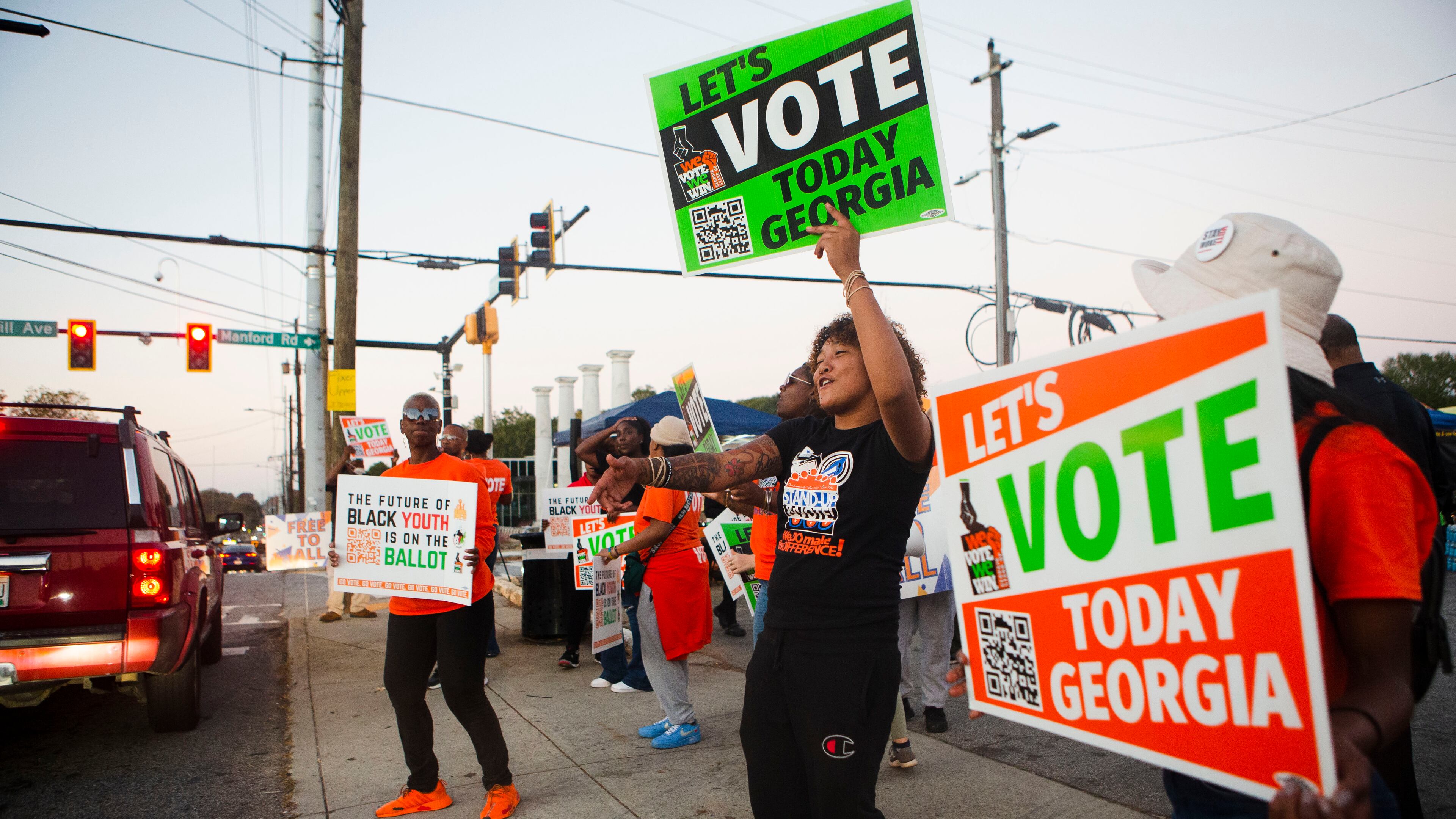 Volunteers encourage citizens to vote on Tuesday, Nov. 8, 2022, across the street from the Metropolitan Library in Atlanta. (Christina Matacotta for The Atlanta Journal-Constitution)