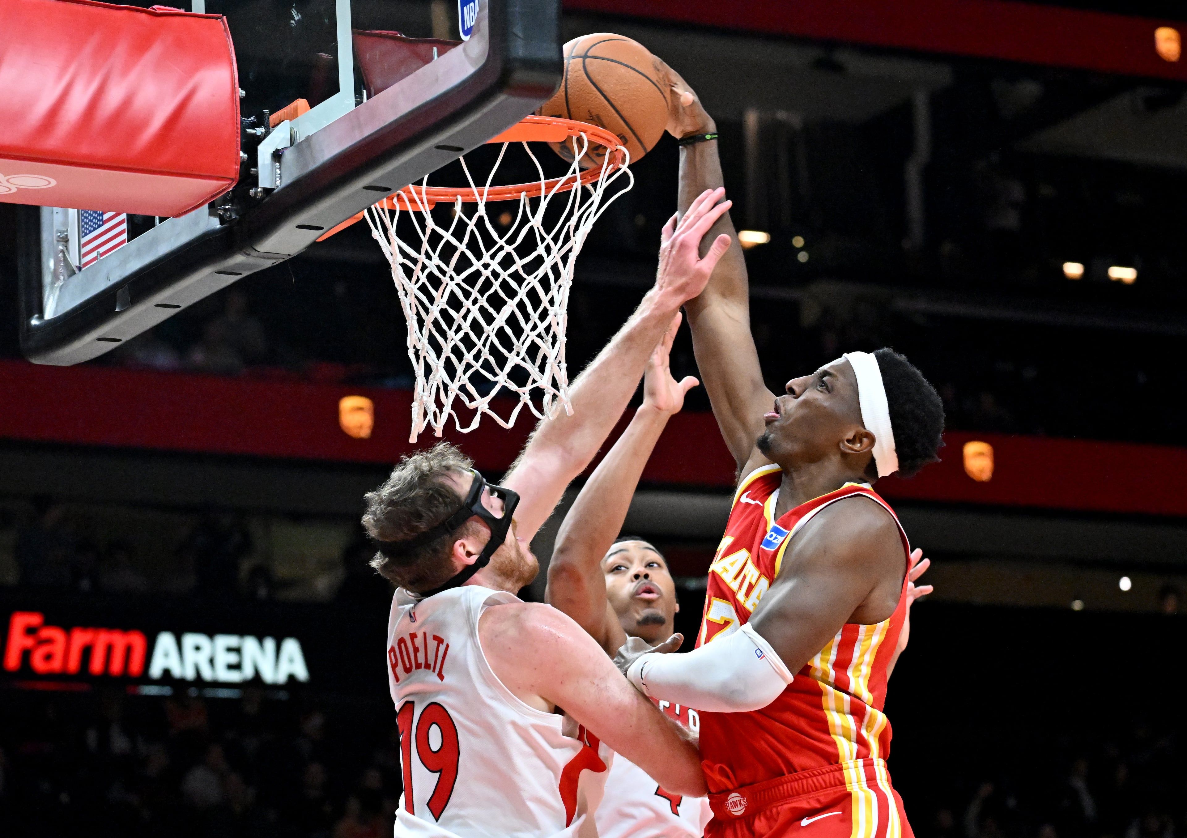 Atlanta Hawks forward/center Onyeka Okongwu (17) dunks the ball against Toronto Raptors center Jakob Poeltl (19) during the second half in the home opener at State Farm Arena, Thursday, October 22, 2025, in Atlanta. Toronto Raptors won 138-118 over Atlanta Hawks. (Hyosub Shin / AJC)