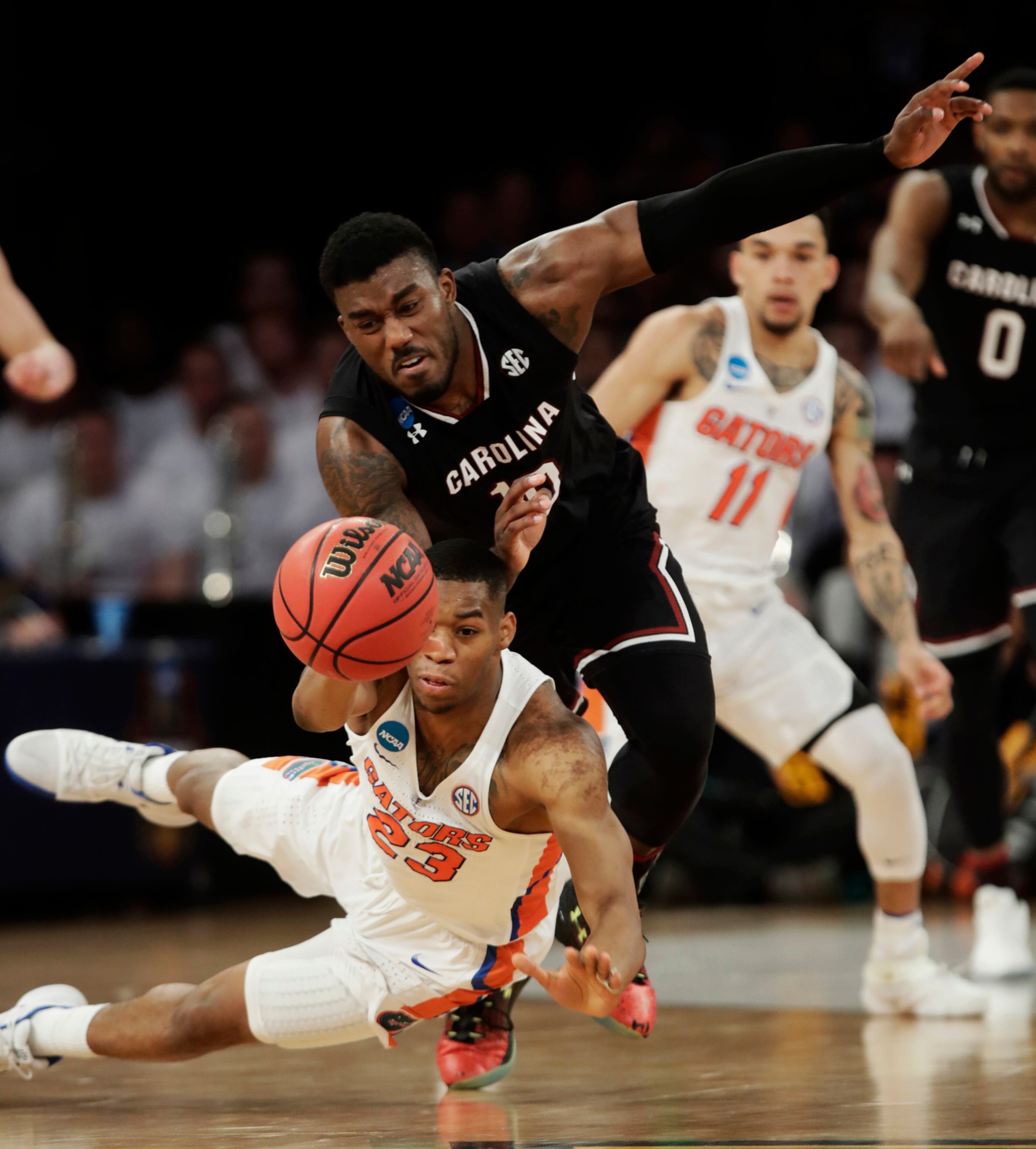 Florida forward Justin Leon (23) and South Carolina guard Duane Notice (10) scramble for a loose ball during the second half of the East Regional championship game of the NCAA men's college basketball tournament, Sunday, March 26, 2017, in New York. (AP Photo/Frank Franklin II)