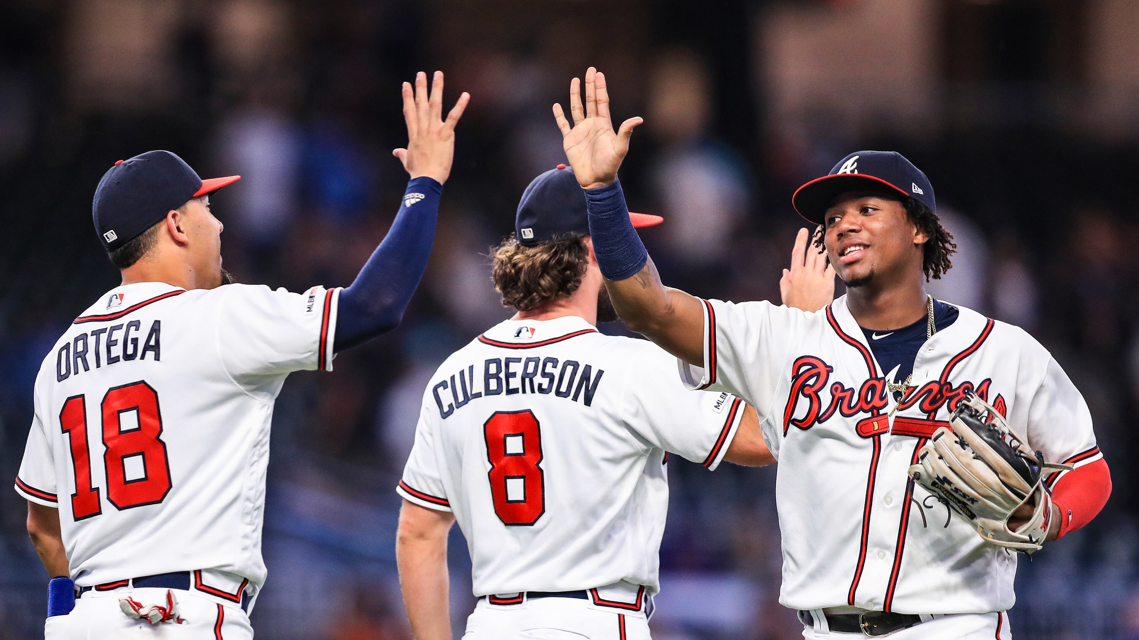Ronald Acuna Jr. #13 high fives Rafael Ortega #18 of the Atlanta Braves following the game against the New York Mets at SunTrust Park on August 14, 2019 in Atlanta, Georgia. (Photo by Carmen Mandato/Getty Images)