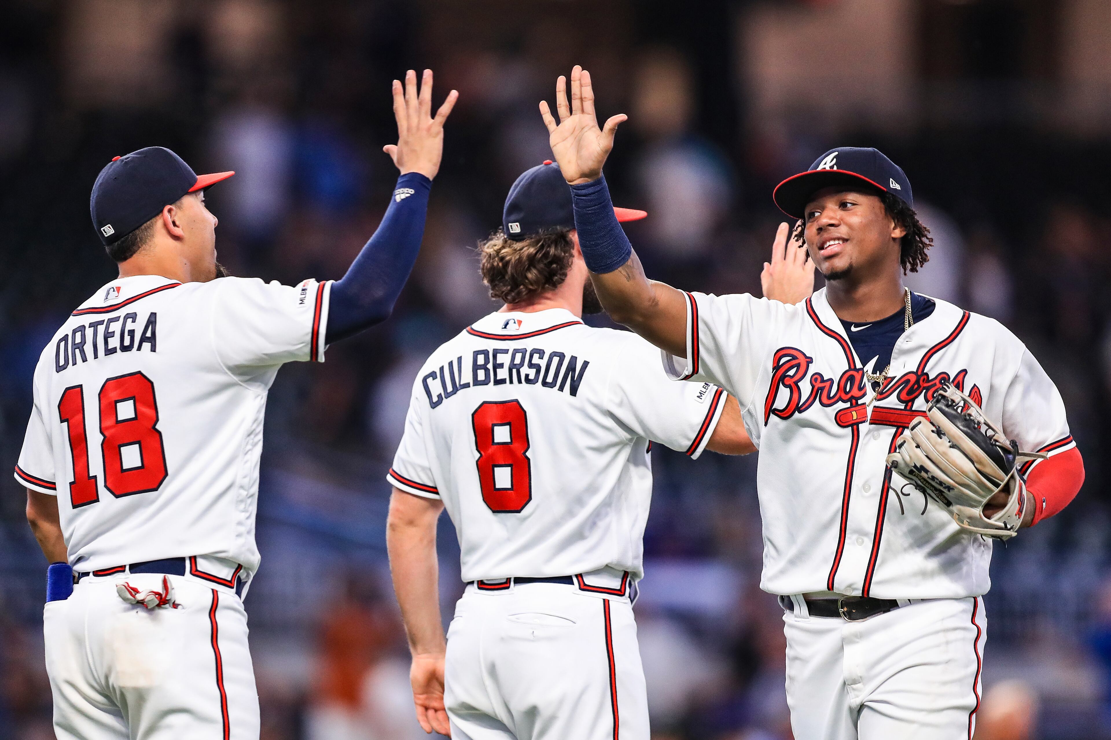 Ronald Acuna Jr. #13 high fives Rafael Ortega #18 of the Atlanta Braves following the game against the New York Mets at SunTrust Park on August 14, 2019 in Atlanta, Georgia. (Photo by Carmen Mandato/Getty Images)