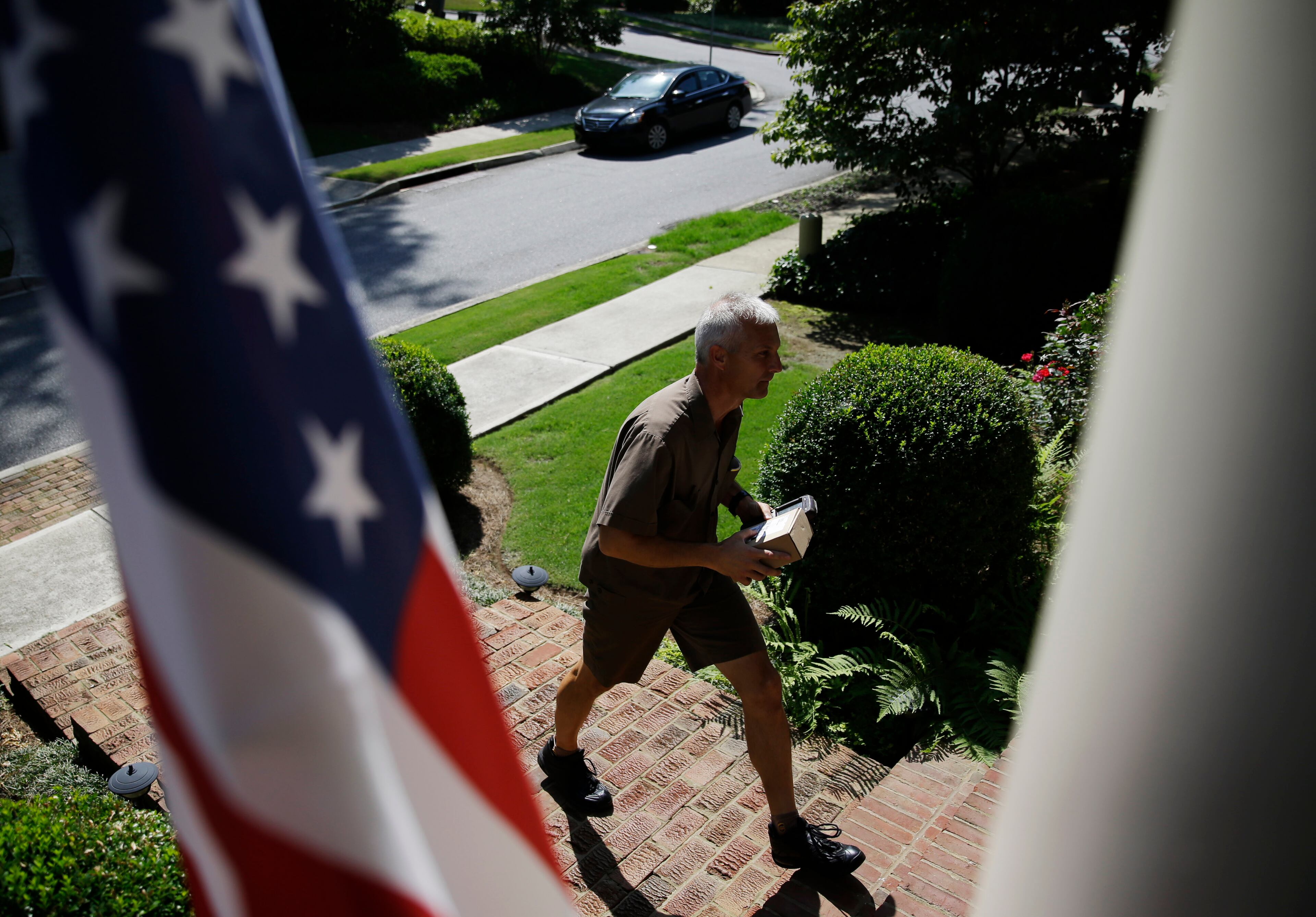 In this June 20, 2014 photo, United Parcel Service driver Marty Thompson makes a delivery in Cumming, Ga. (AP Photo/David Goldman)