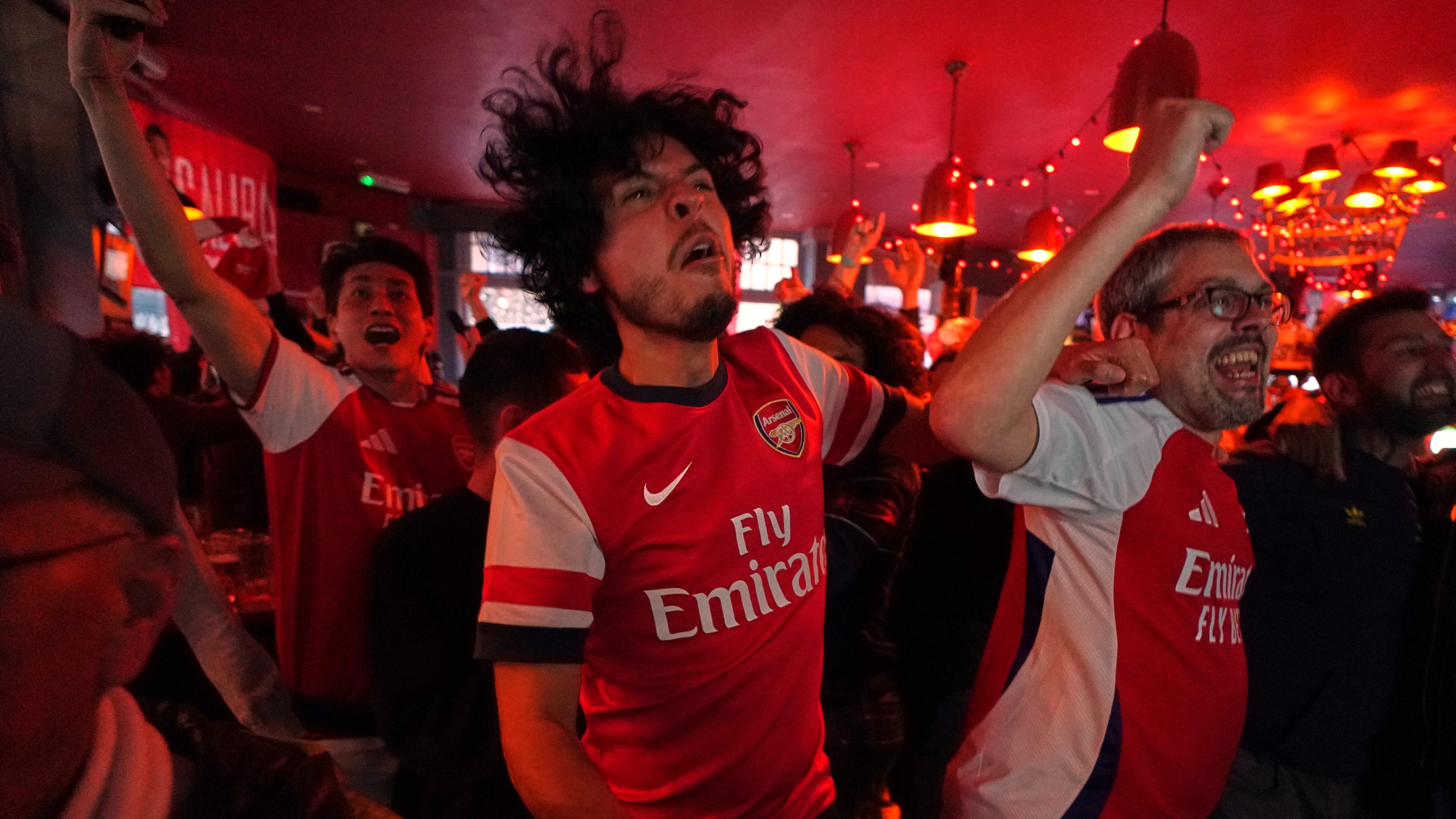 Arsenal supporters celebrate as they watch the Premier League match between Bournemouth and Manchester City in a pub near the Arsenal stadium in London, Tuesday, May 19, 2026.(AP Photo/Alberto Pezzali)