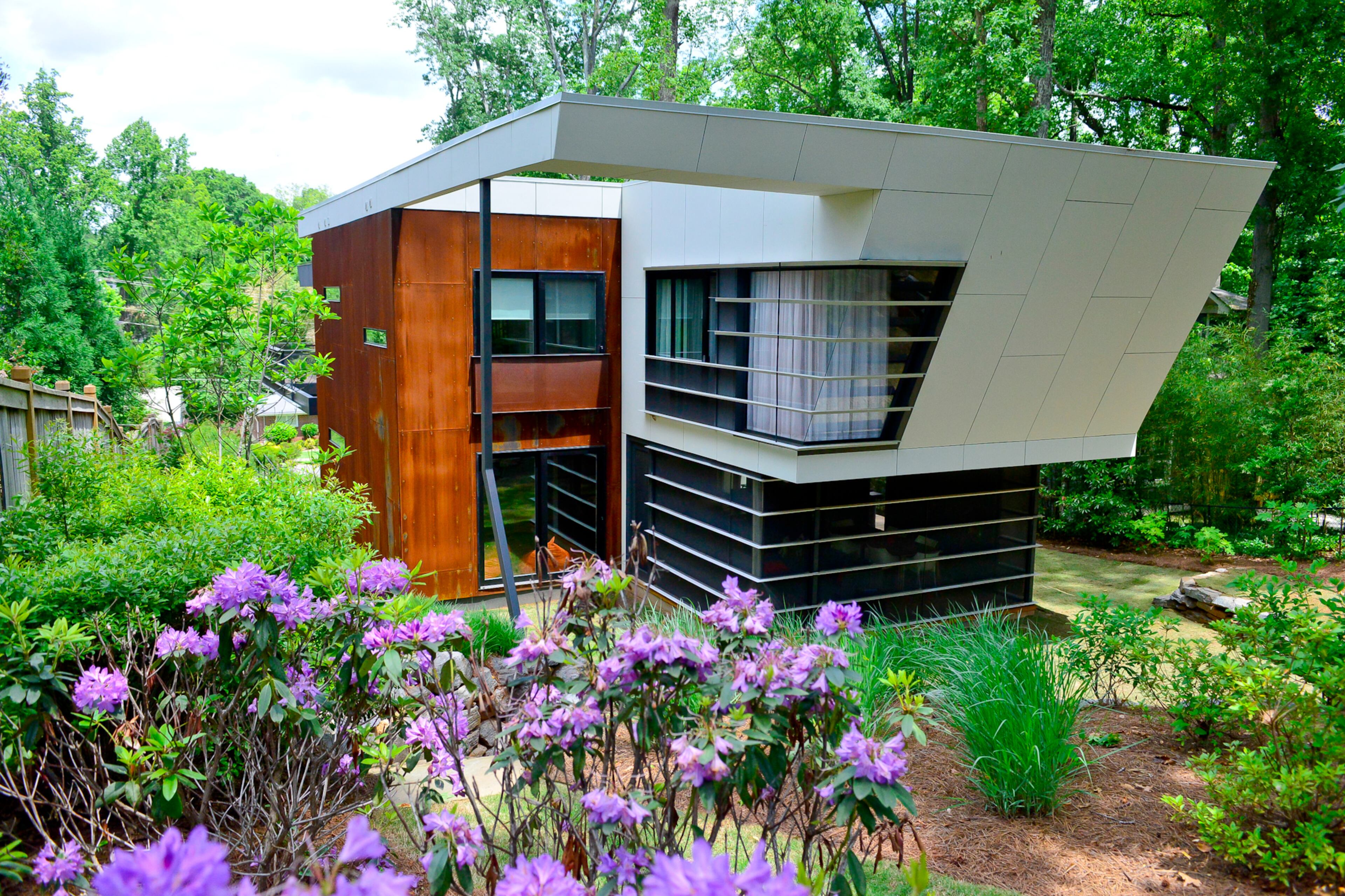 The Decatur house was designed to be fun for the family of four and functional, since writers Bret Witter and his wife, Elizabeth Butler-Witter work there. The curtained corner is the master bathroom, and underneath, there's one of two screened porches.--Text by Lori Johnston (Christopher Oquendo Photography)