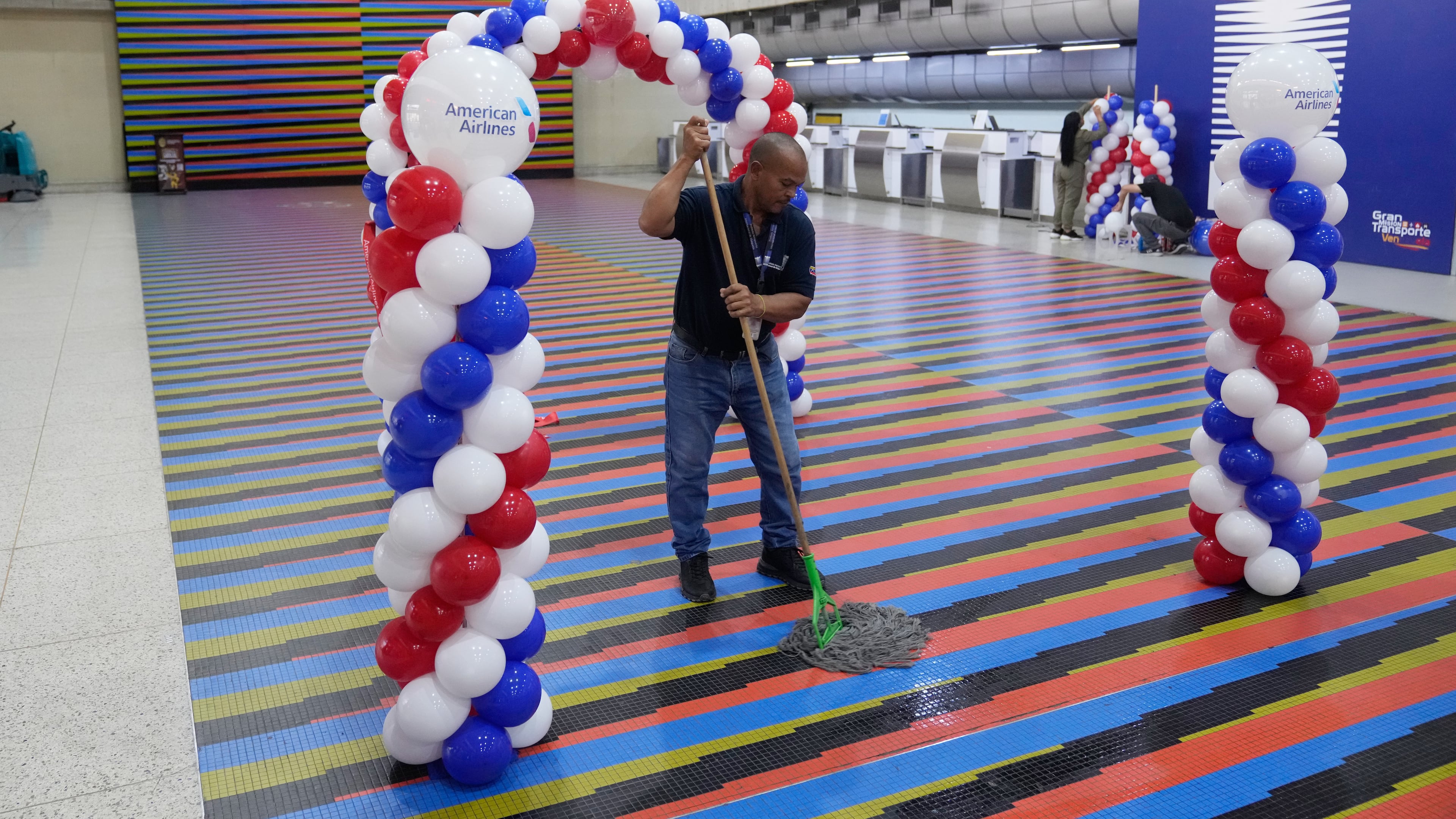 A worker cleans the check-in area ahead of the arrival of a U.S. commercial flight at Simon Bolivar International Airport in Maiquetia, Venezuela, Thursday, April 30, 2026, as direct air service between the United States and Venezuela resumes after seven years. (AP Photo/Ariana Cubillo)
