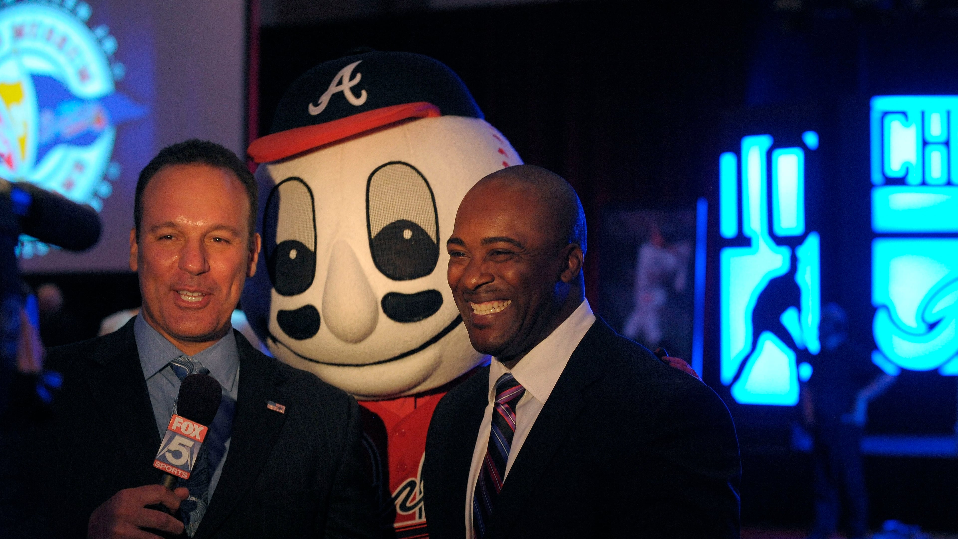 Former Braves player Ron Gant (right) participates in a TV interview before honoring Chipper Jones during a 2013 luncheon in Atlanta. Gant played a pivotal role as starting left fielder and cleanup hitter during the Braves’ “worst to first” 1991 season. (David Tulis for the AJC)