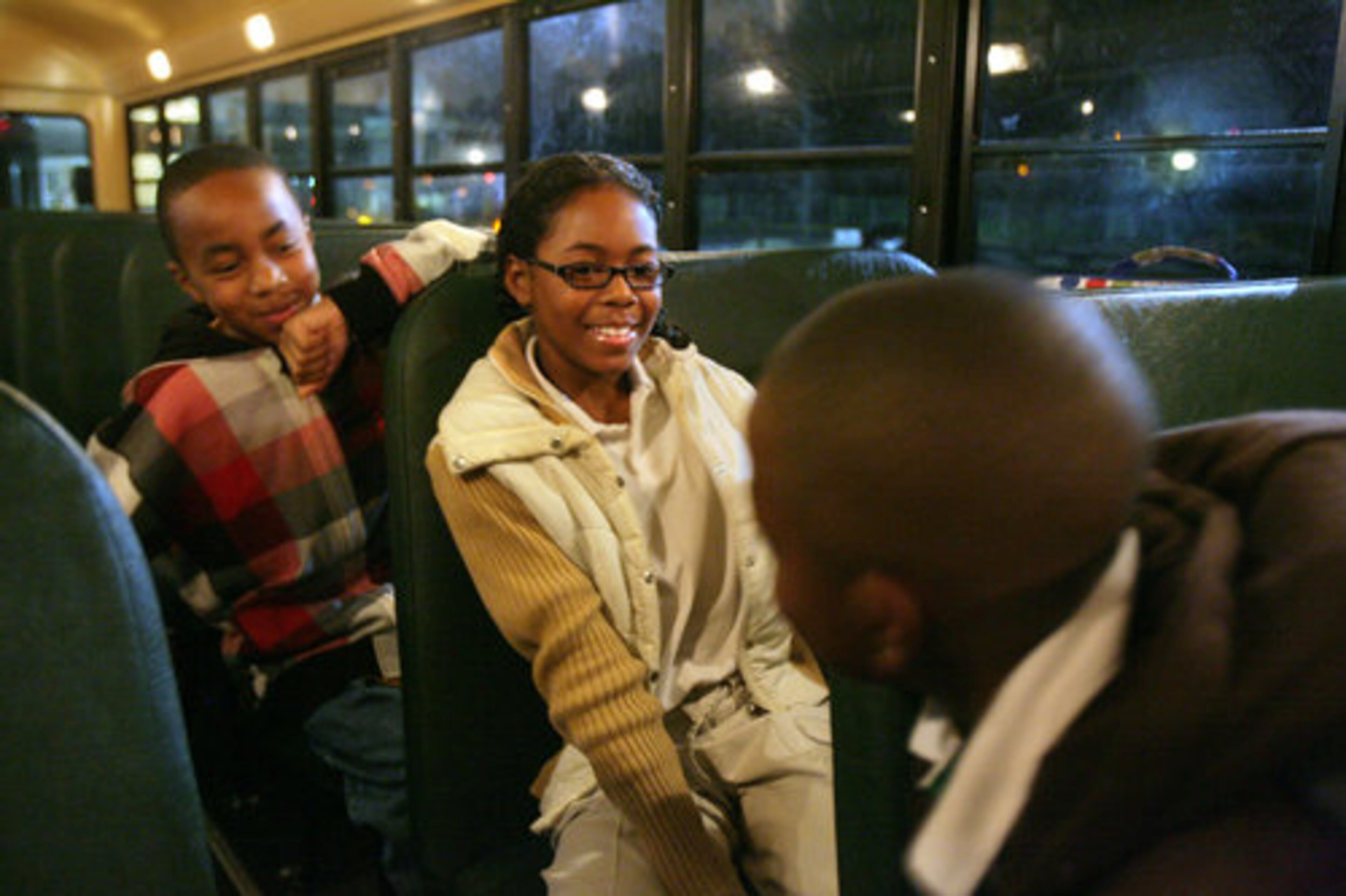 Michael Turner (left, 10), Ajah Garrison (9, center) and Quentin Lovelace (also 9) wait in their DeKalb County school bus at Oak View Elementary School this morning.