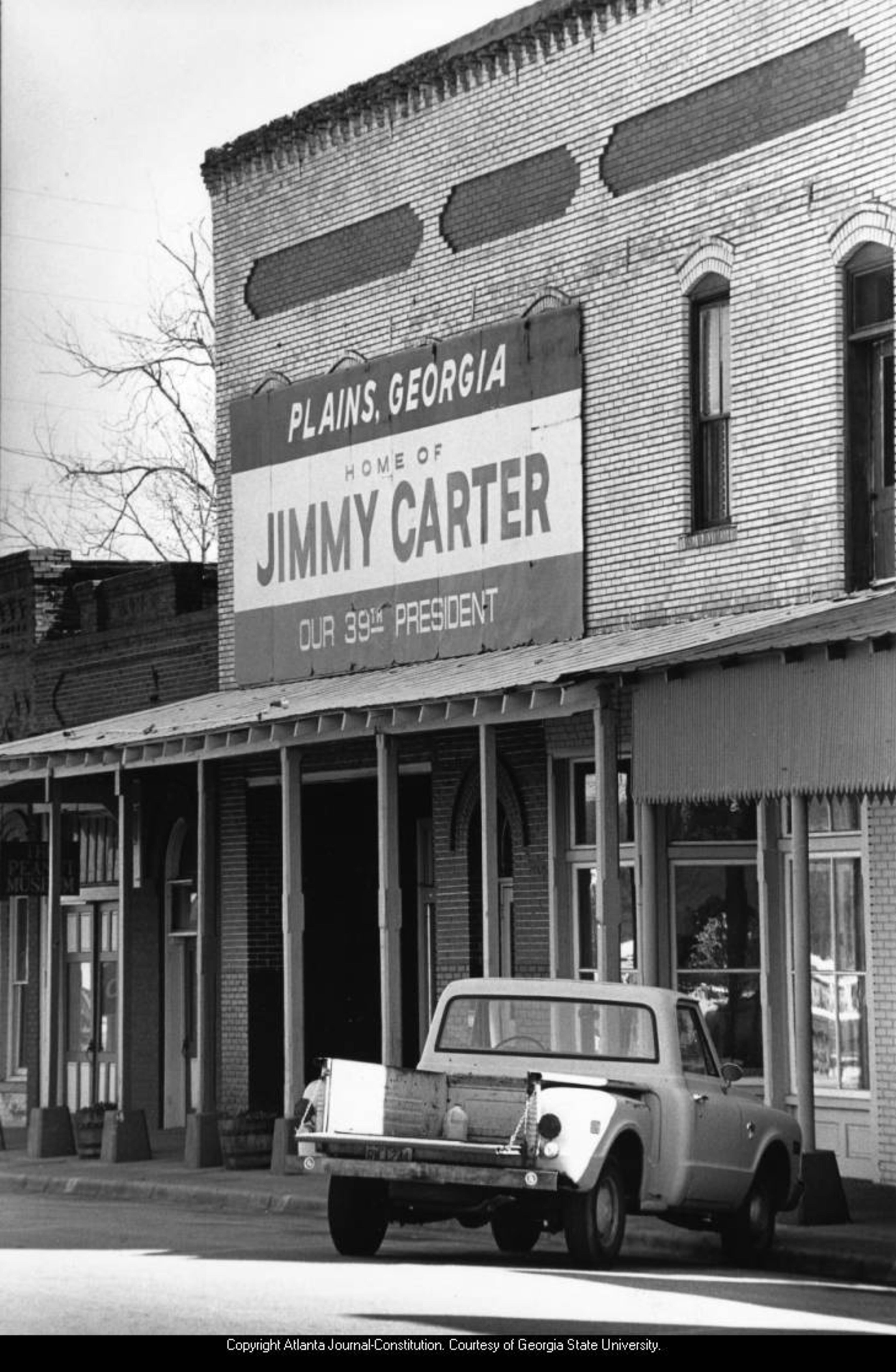 1988 -- A sign on a Plains, Ga., storefront touts the southwest Georgia town's fame as the home of President Jimmy Carter. LOUIE FAVORITE / AJC FILE