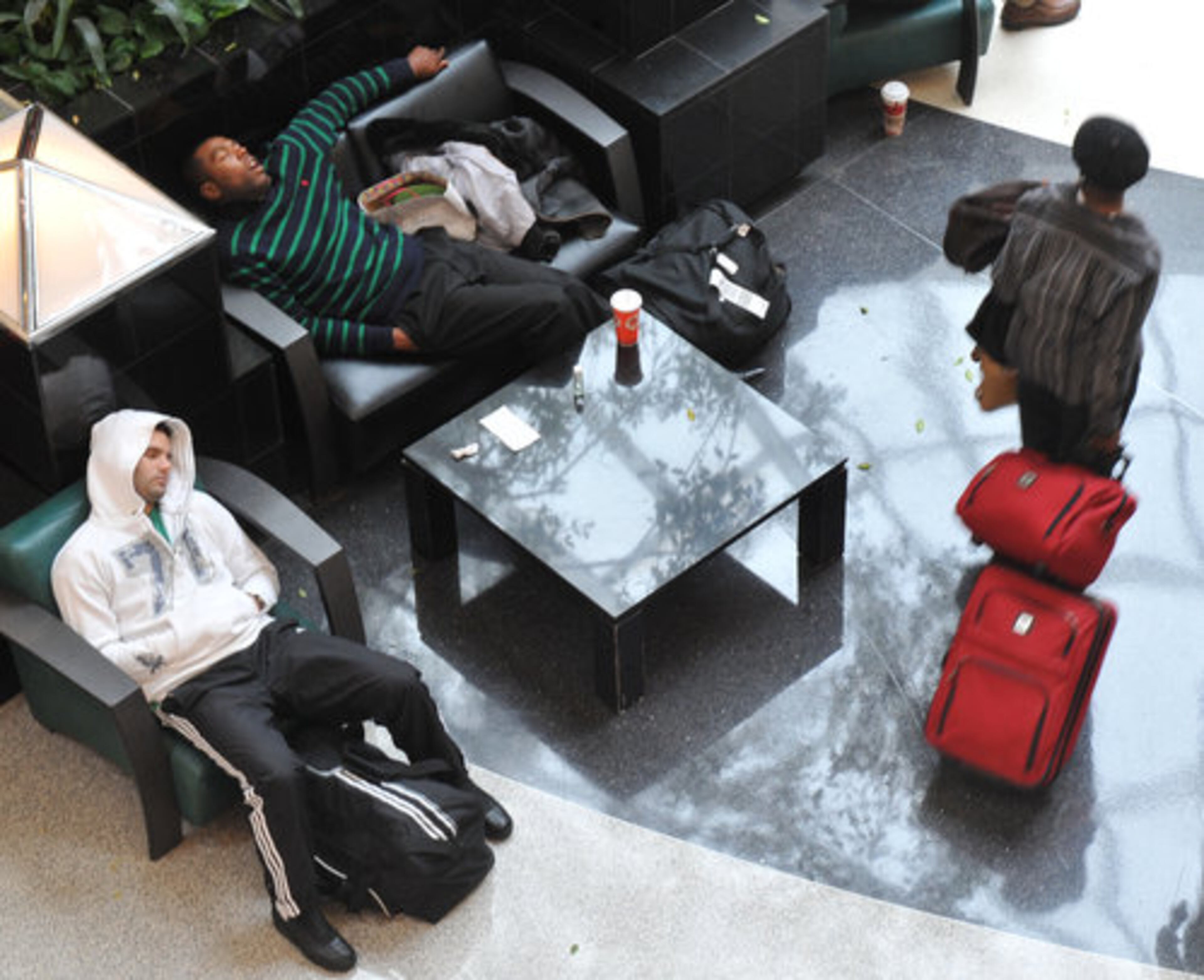 Devin Rodgers (top left) who arrived from New York early Tuesday, Nov. 23, 2010, snoozes while waiting for his sister to pick him up.