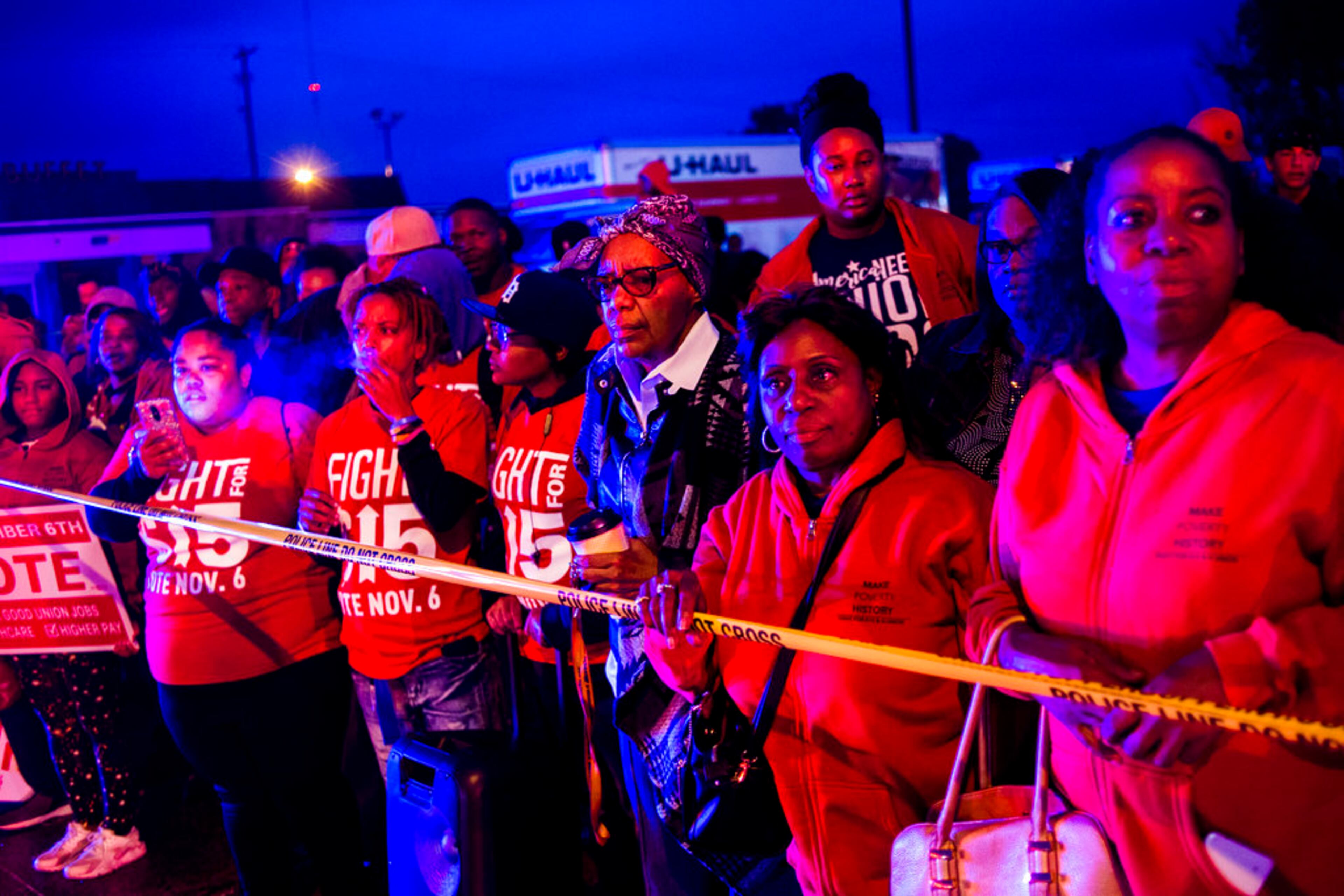 Protesters stand behind police tape, watching as police and first responders tend to the scene after a truck collided with into protesters calling for the right to form unions Tuesday, Oct. 2, 2018, in Flint, Mich. Police said the collision appears to be an accident. (Jake May/The Flint Journal via AP)