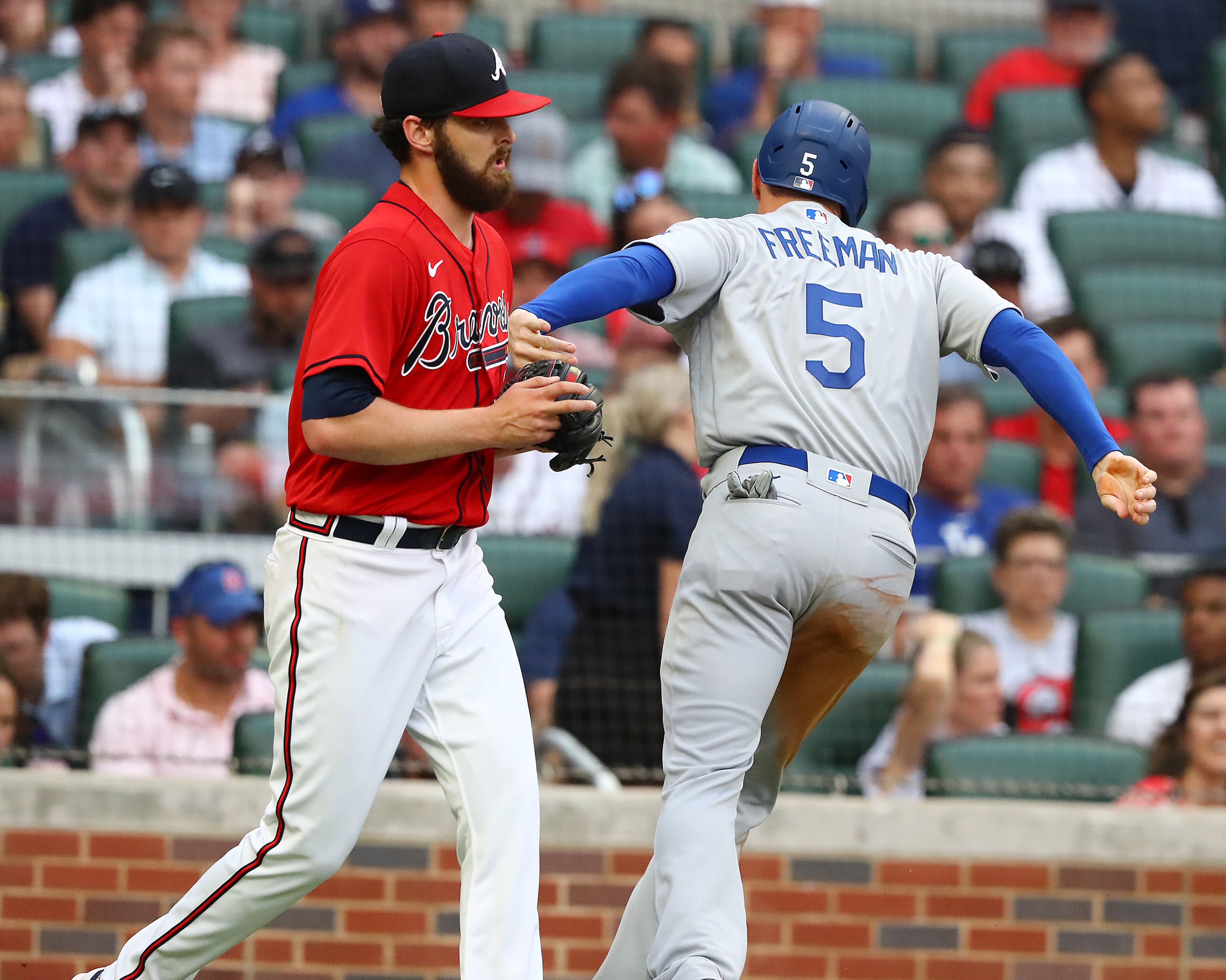 062422 Atlanta: Los Angles Dodgers Freddie Freeman scores a run from third base on a sacrafice fly by Justin Turner for a 2-0 lead over the Atlanta Braves giving Braves starting pitcher Ian Anderson a pat on the chest during the first inning a MLB baseball game on Friday, June 24, 2022, in Atlanta. The series marks Freeman’s first games in Atlanta since the longtime Braves star signed with the Dodgers as a free agent in March. “Curtis Compton / Curtis.Compton@ajc.com”