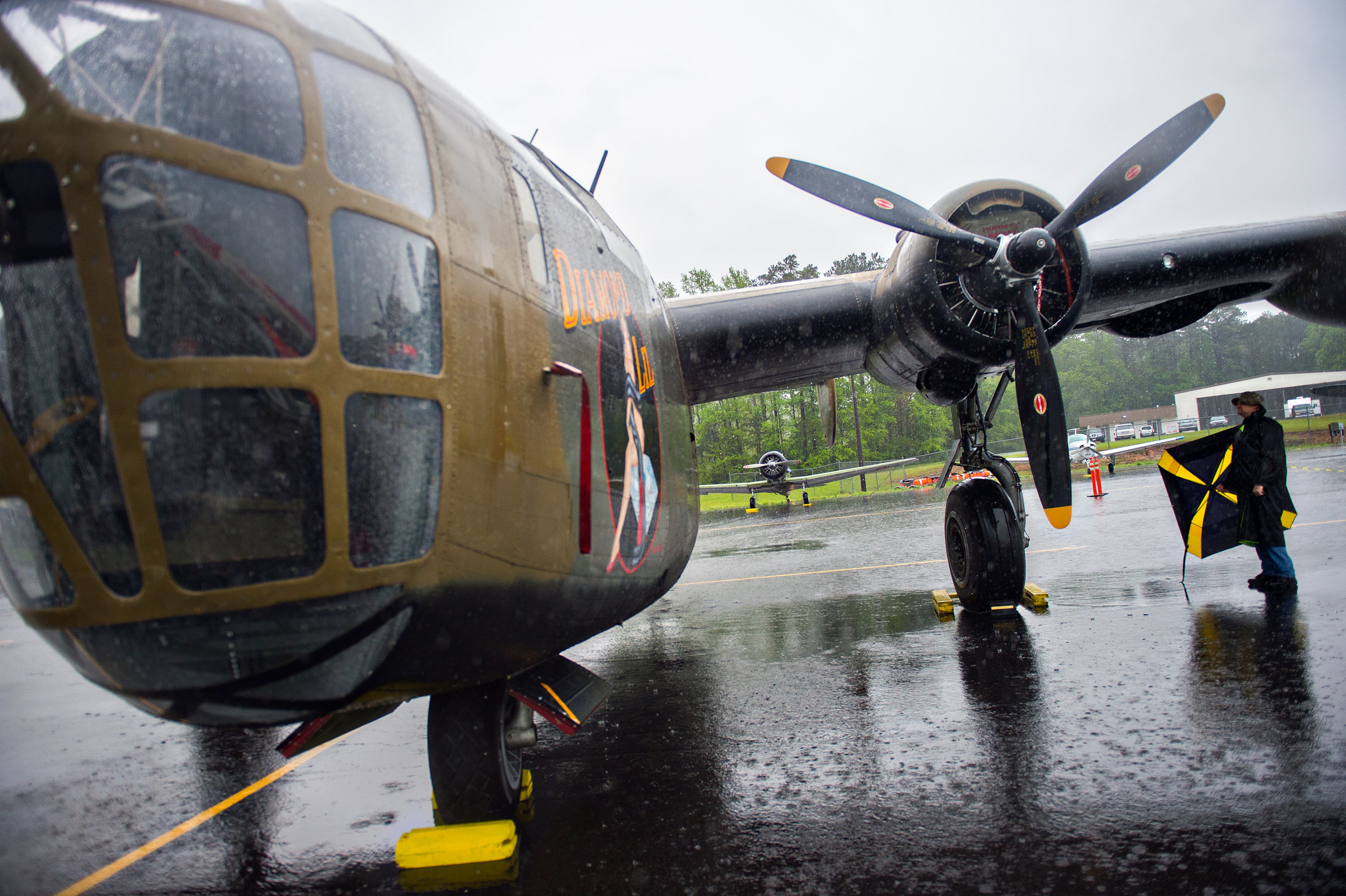 Andrew Hartpence stands underneath the wing of a World War II era B-24 bomber as he tries to stay dry during WWII Heritage Days at Atlanta Regional Airport Falcon Field in Peachtree City on Sunday, April 19, 2015. The two day celebration, hosted by the Commemorative Air Force (CAF) Dixie Wing, featured re-enactors, WWII veterans, military vehicles, vintage warbirds and living history exhibits. JONATHAN PHILLIPS / SPECIAL