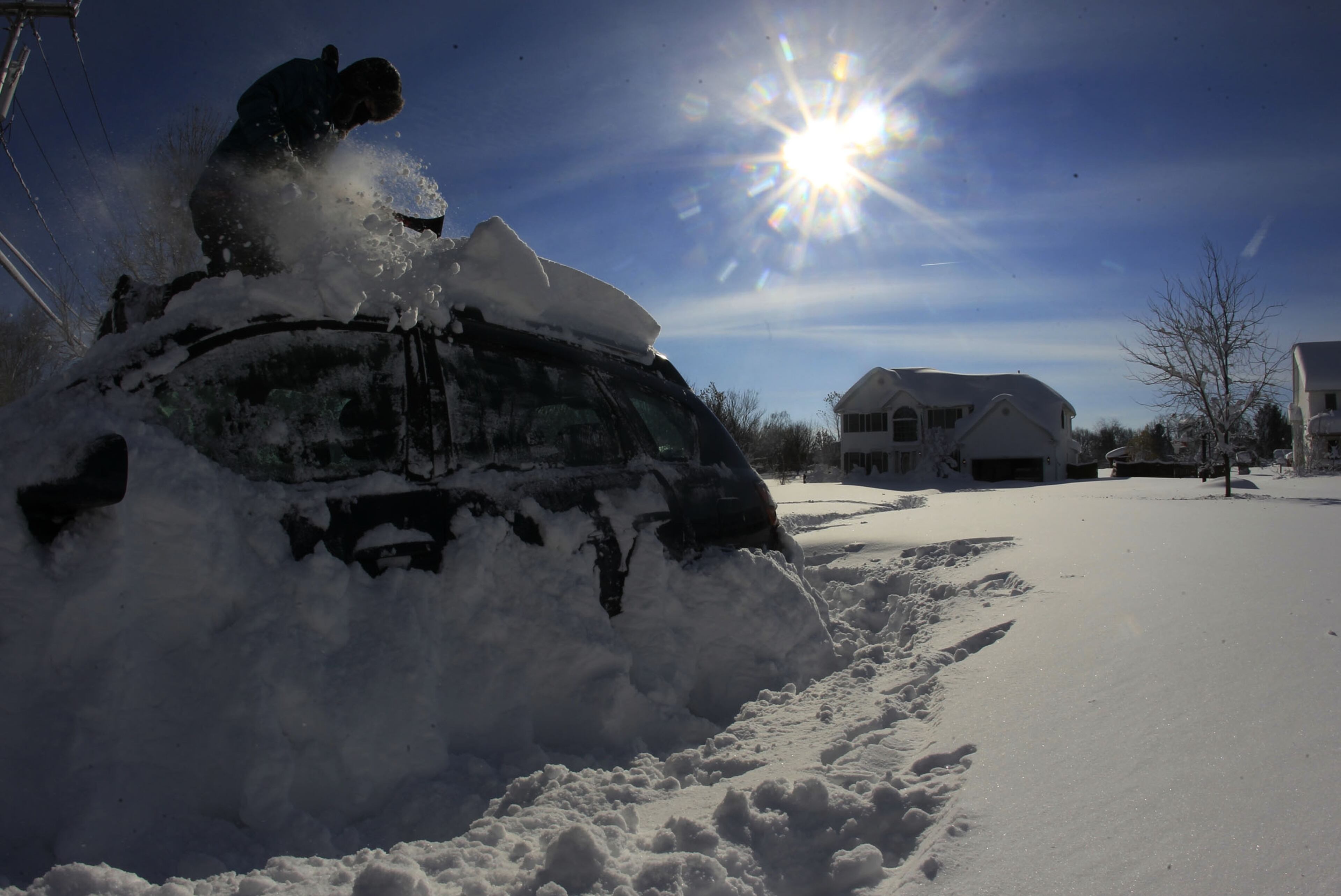 Braeden Attig,11, removes snow from a buried car along Powers Road in Orchard Park, N.Y. on Wednesday, Nov. 19, 2014. A ferocious lake-effect storm left the Buffalo area buried under 6 feet of snow Wednesday, trapping people on highways and in homes, and another storm expected to drop 2 to 3 feet more was on its way. (AP Photo/The Buffalo News, Harry Scull Jr.)